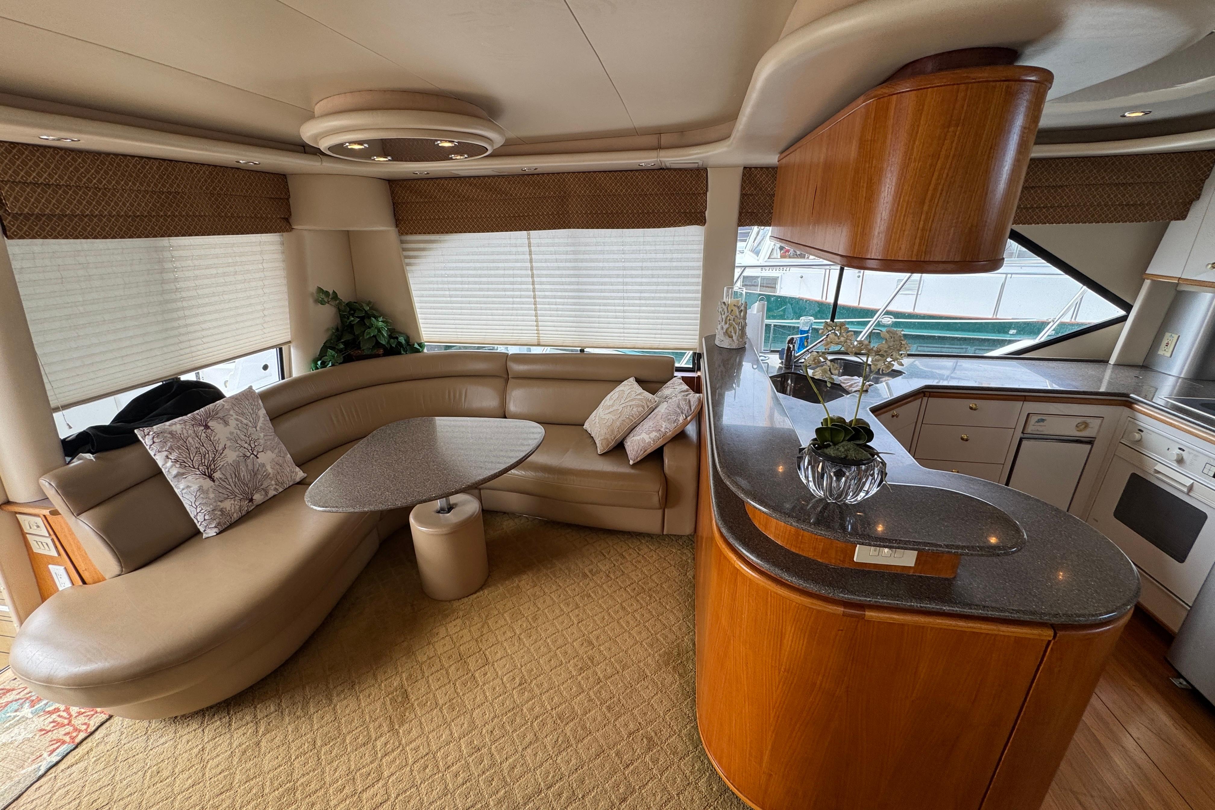Luxurious interior of a 1998 Bayliner 5788 Pilot House Motoryacht with elegant seating and kitchen area.