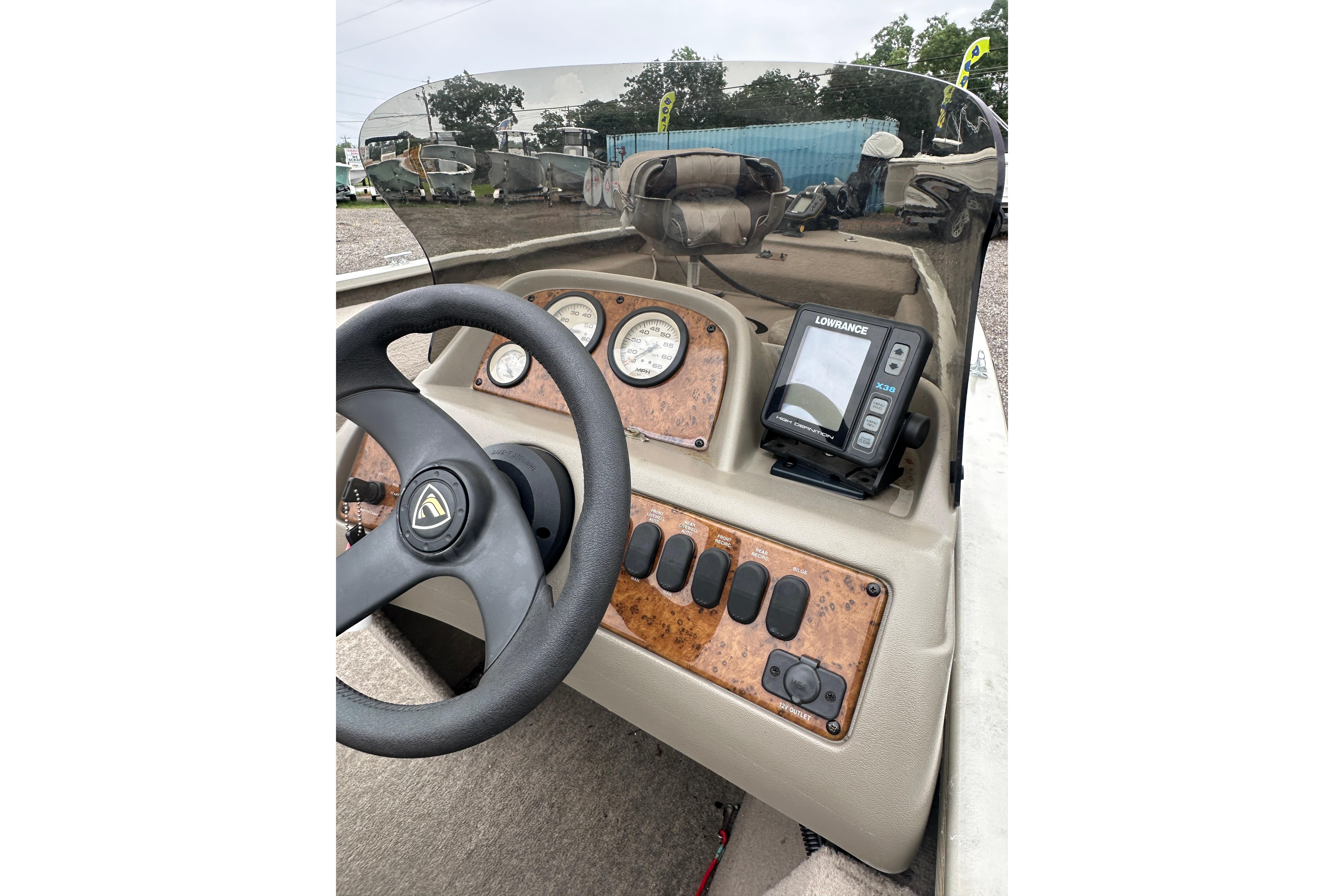 Console of a 2002 Fisher 1710 boat with steering wheel and gauges.