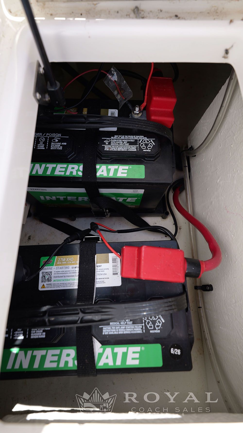 Batteries in a boat compartment, connected with cables.