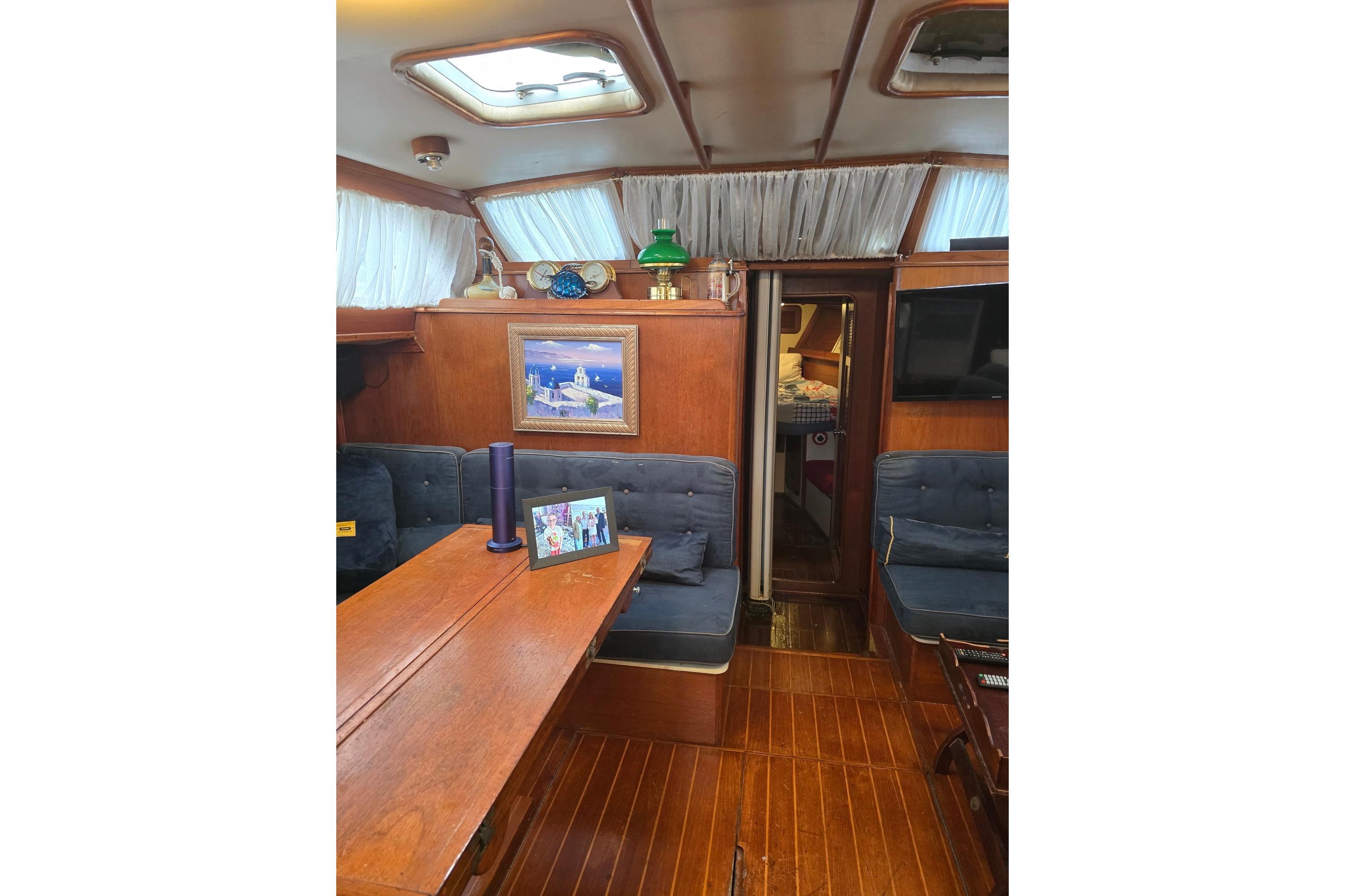 Interior of 1982 Irwin 52 sailboat with wooden furnishings and cozy seating area.