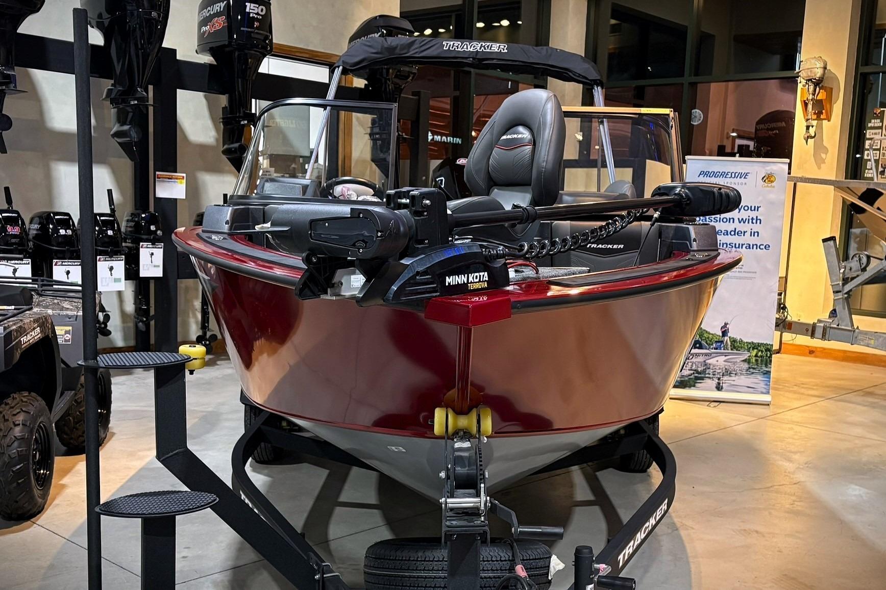 2025 Tracker Targa V-19 WT boat displayed indoors with accessories and promotional materials.