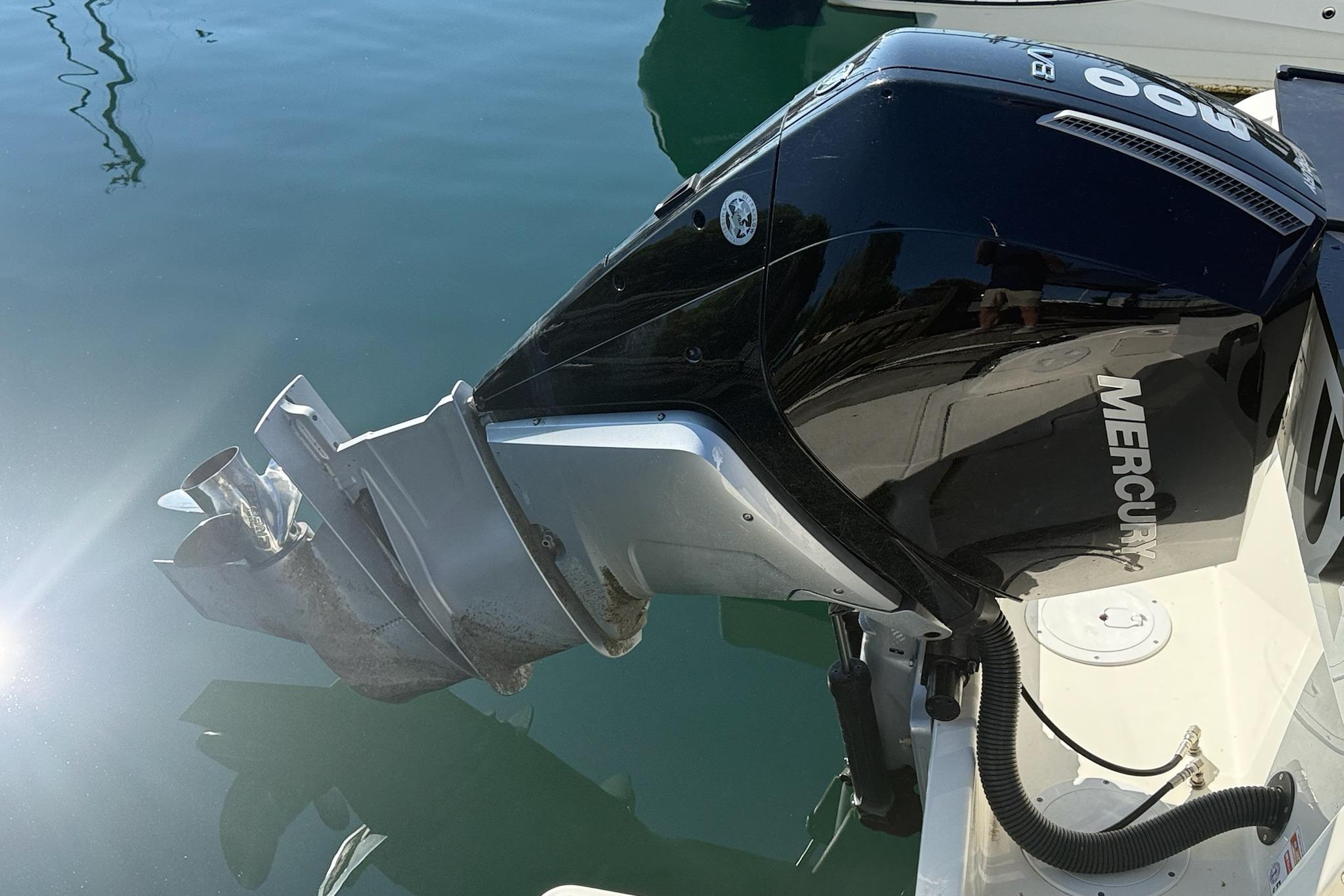 Outboard motor on 2024 Bayliner Trophy T25 Pilothouse, reflecting sunlight on water.