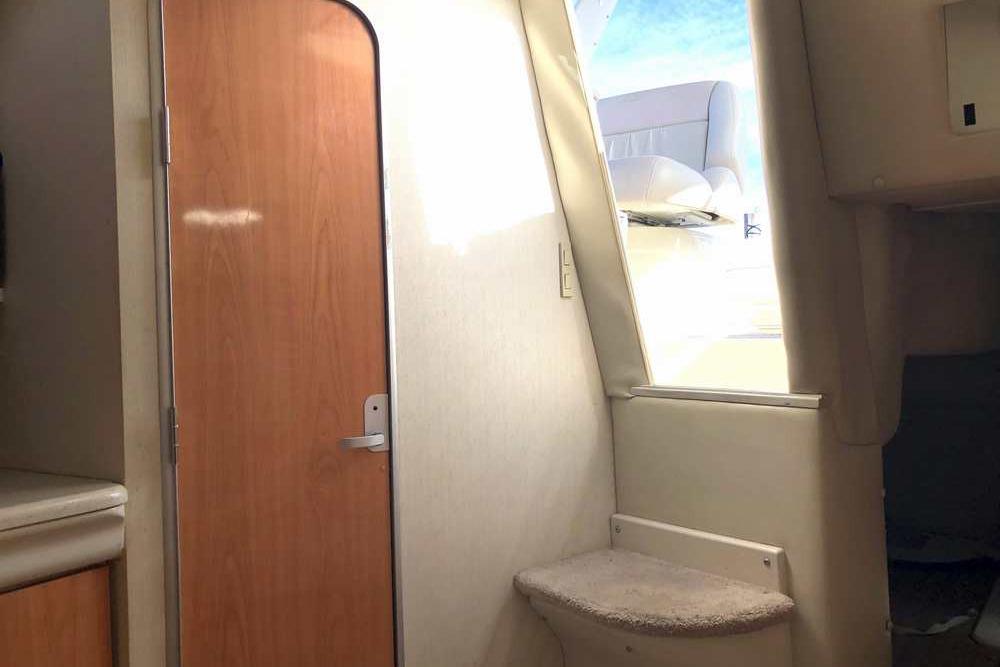 Interior of 1999 Regal Commodore 2760 boat, featuring a wooden door and seating area.