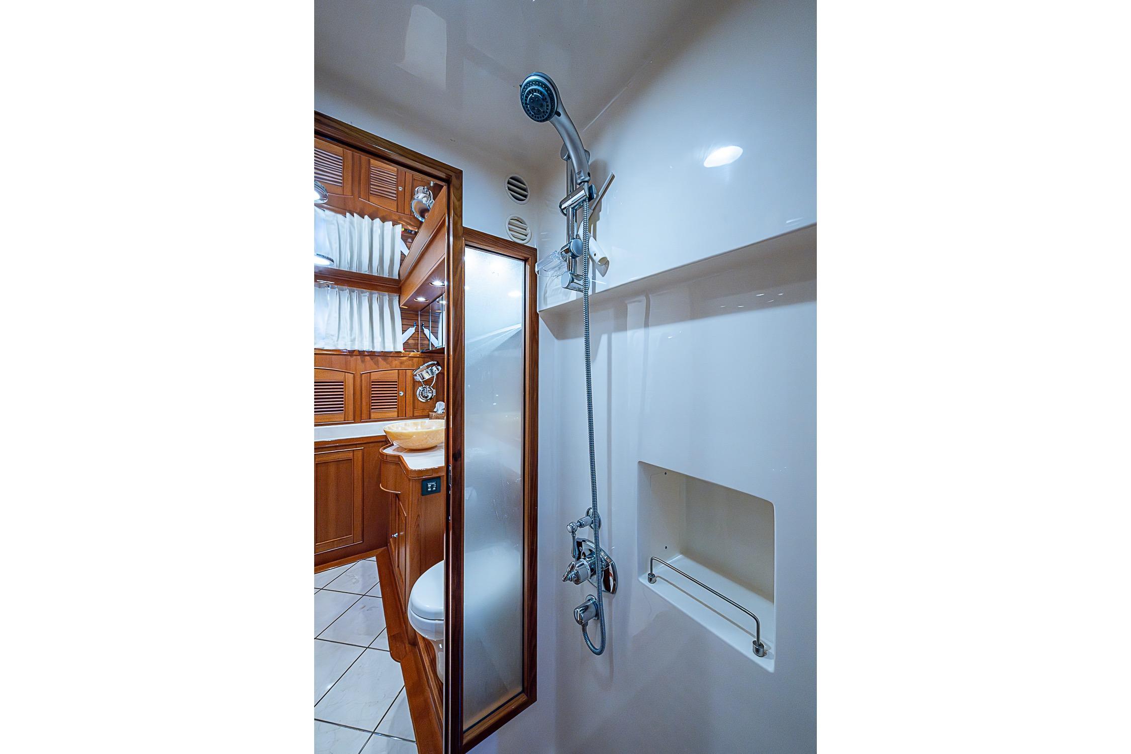 Luxurious bathroom interior of 2014 Marlow 80 Explorer yacht with wooden cabinetry and modern shower.