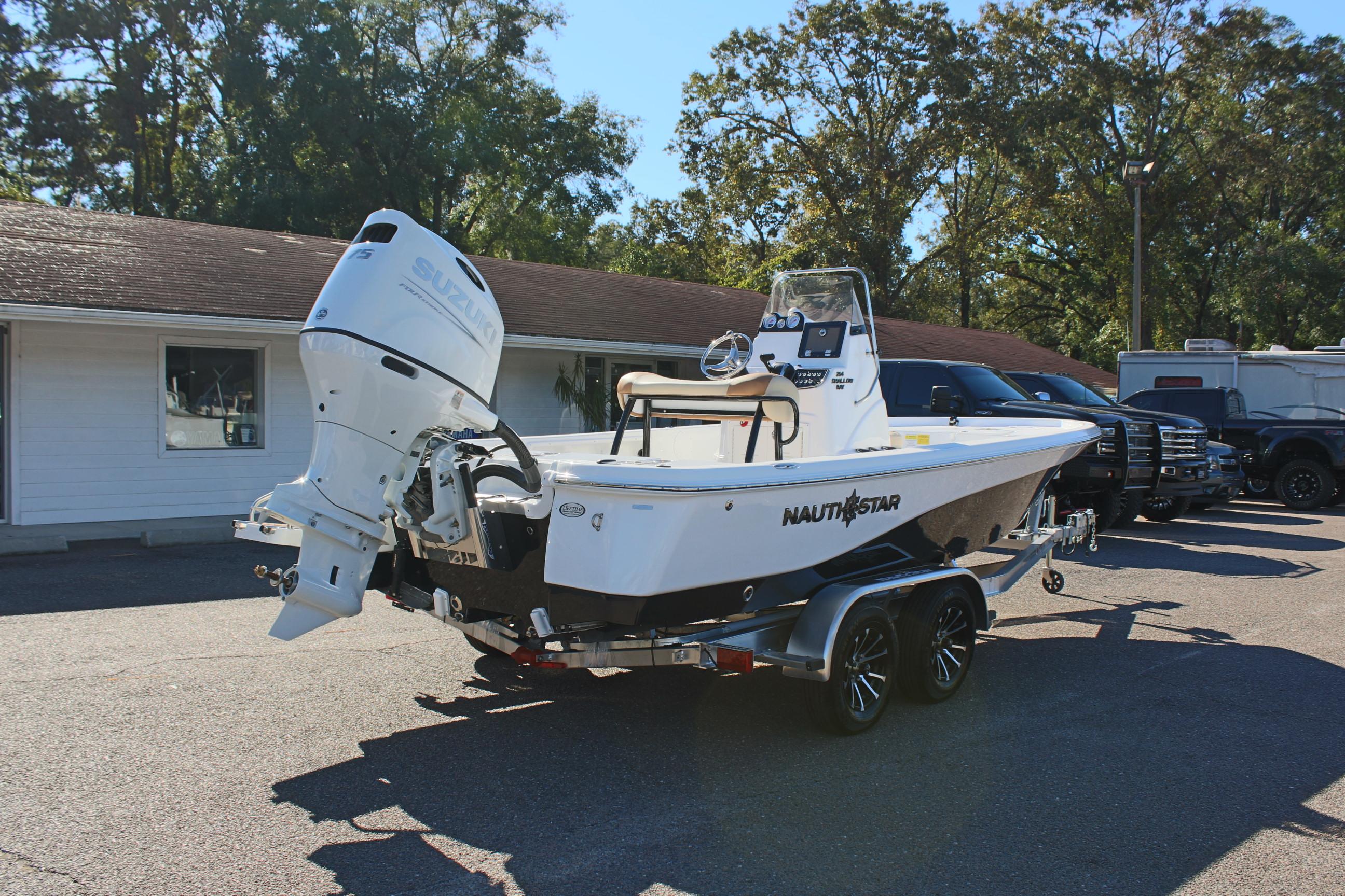 2025 NauticStar 214 Shallow Bay boat on trailer, parked outdoors.