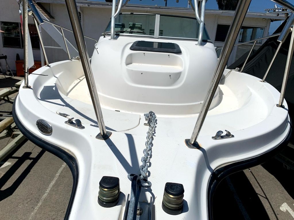 A 2003 Bayliner Walk Around Cuddy Cabin boat with a spacious deck and anchor chain.