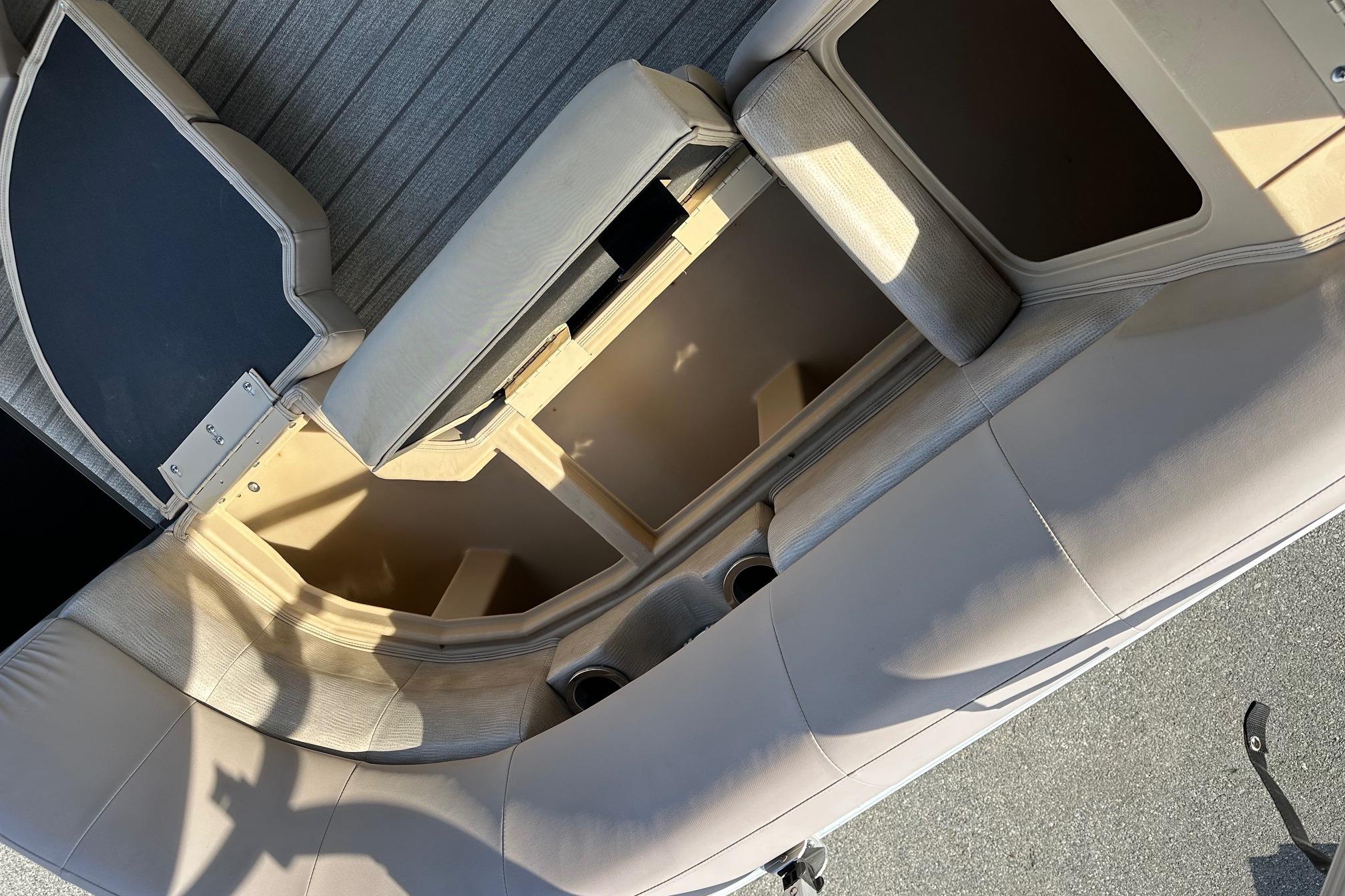 2017 Bennington 22 GPD boat interior with open storage compartments and cushioned seating.