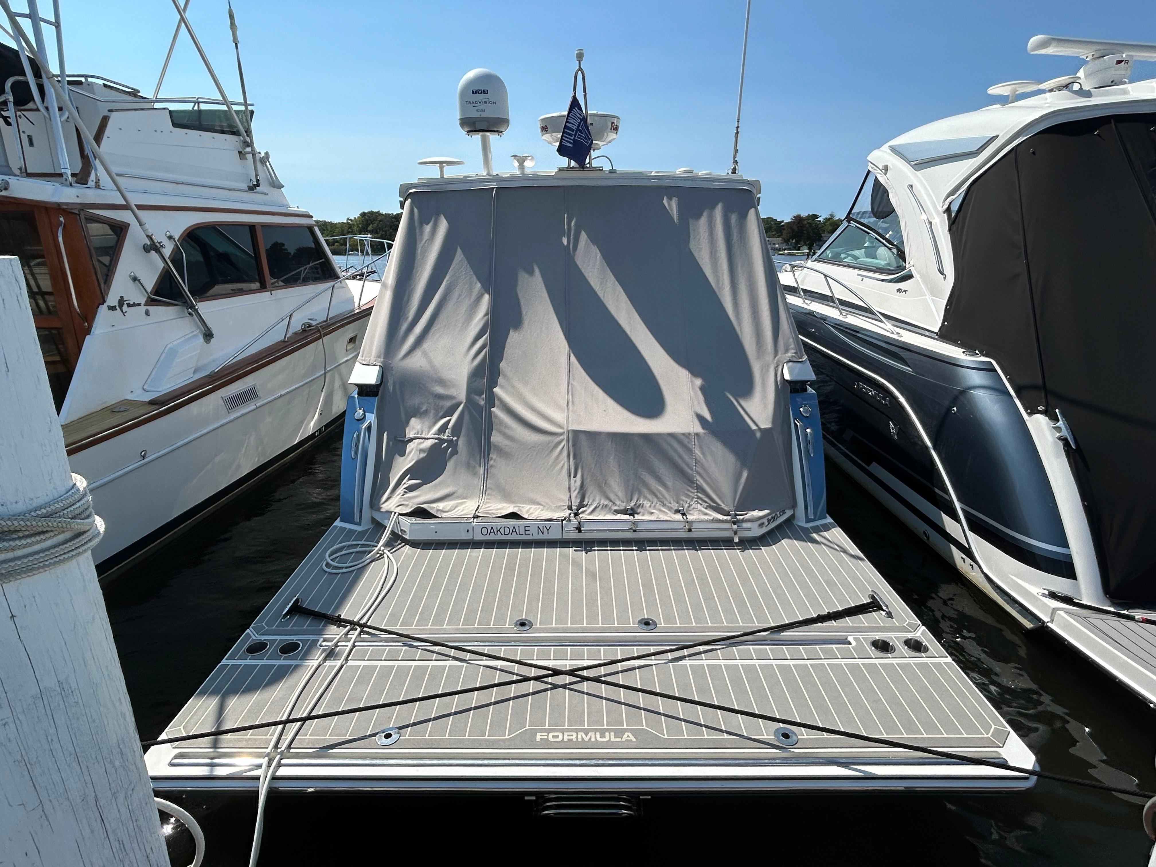 2020 Formula 380 Super Sport Crossover boat docked with cover, surrounded by other boats.