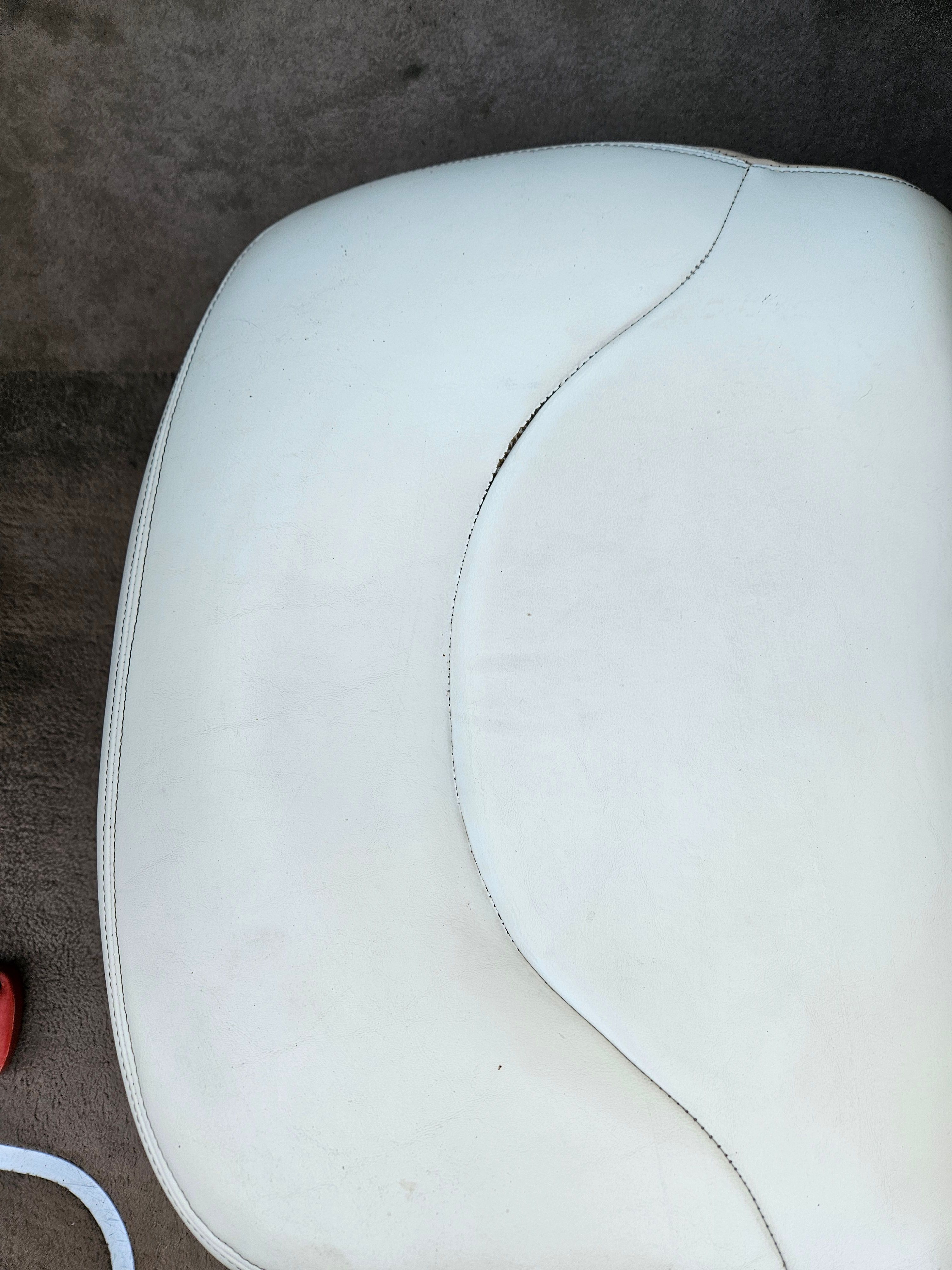 Close-up of a white boat seat with curved stitching.