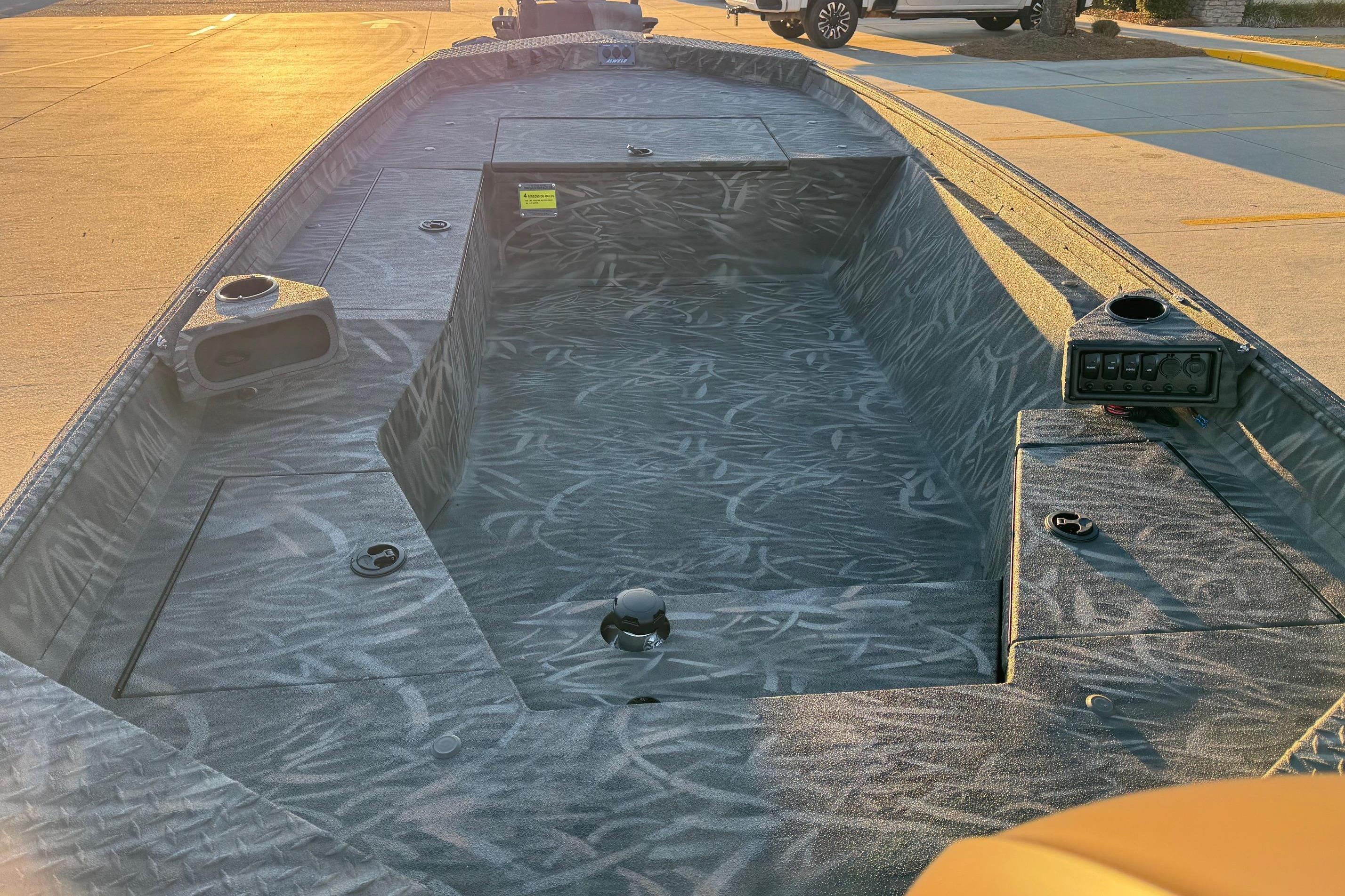 2026 Alweld 1652 Invader boat interior with camo pattern, parked in sunlight.