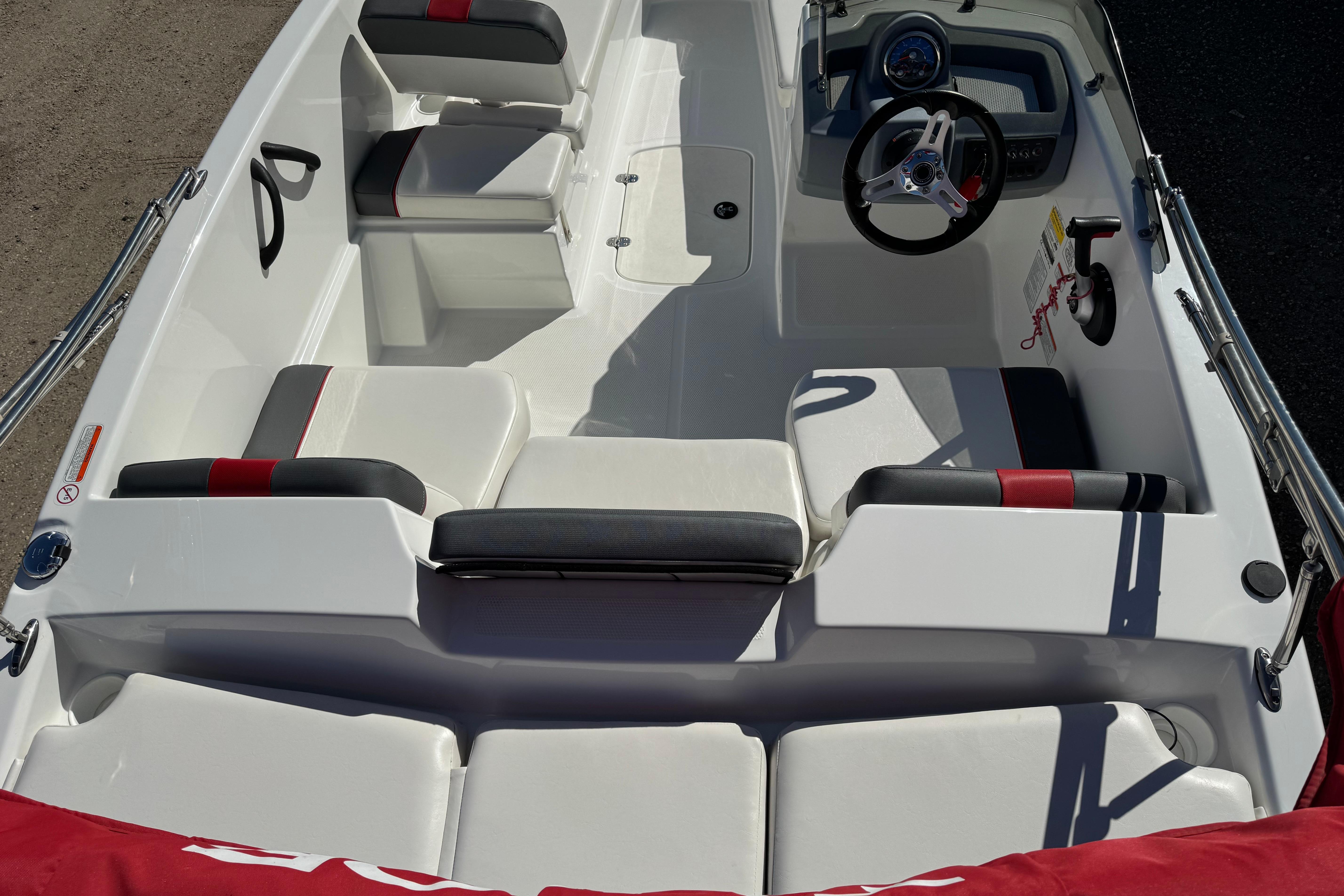 2021 Tahoe T16 boat interior with seating and steering wheel, featuring red and black accents.