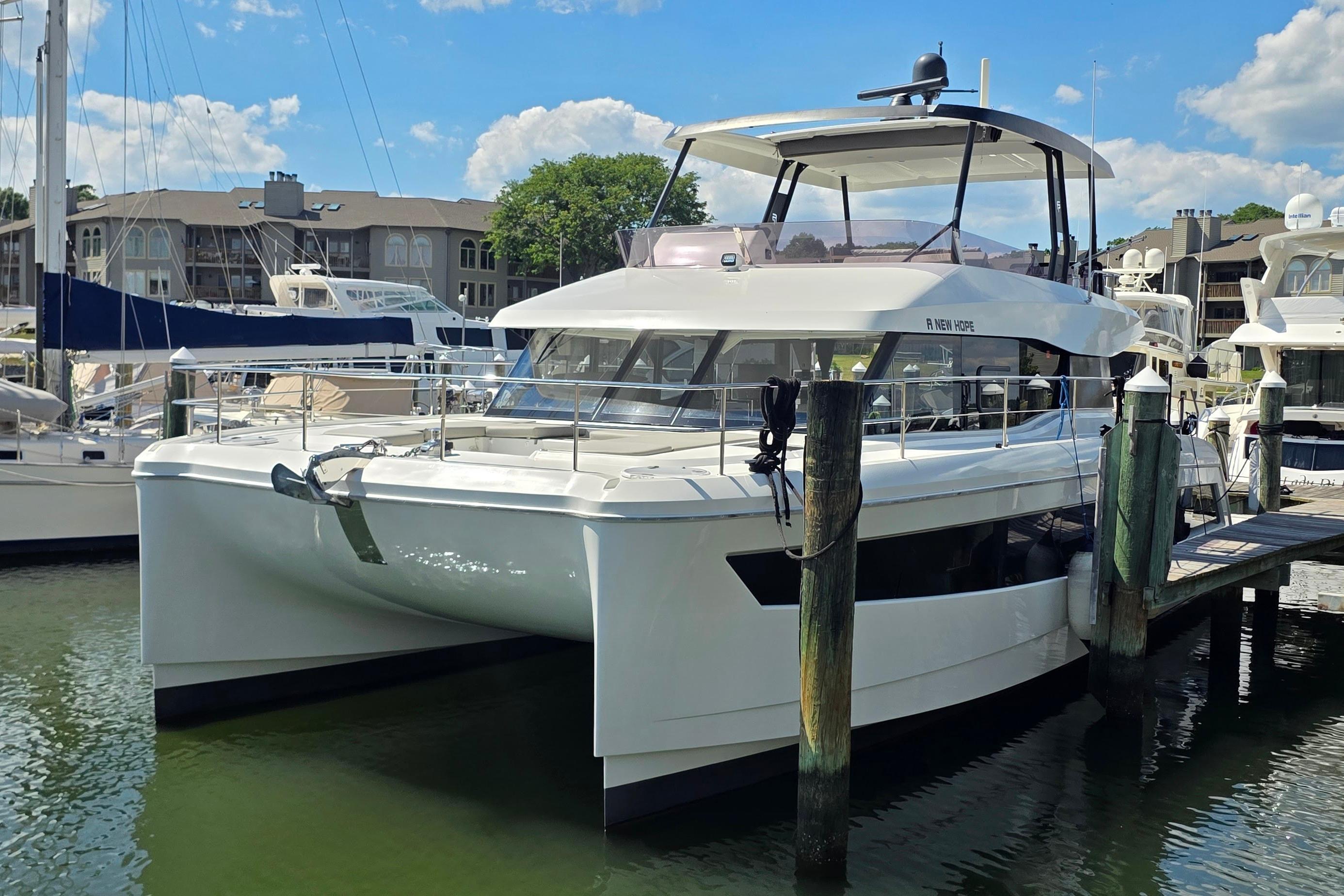 2018 Fountaine Pajot Motor Yacht 44 docked at marina under blue sky.
