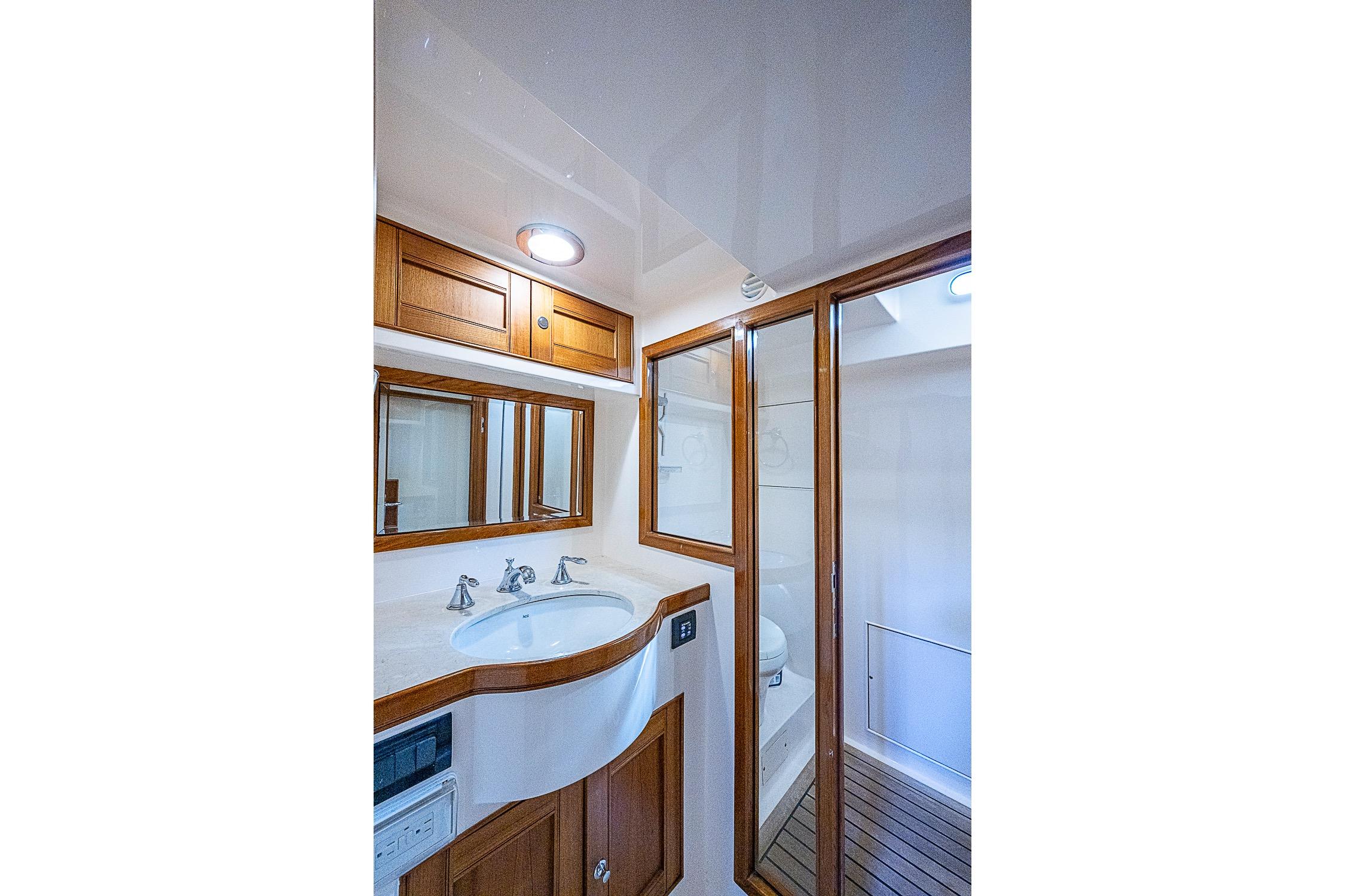 Luxurious bathroom in 2014 Marlow 80 Explorer yacht with wooden accents and modern fixtures.