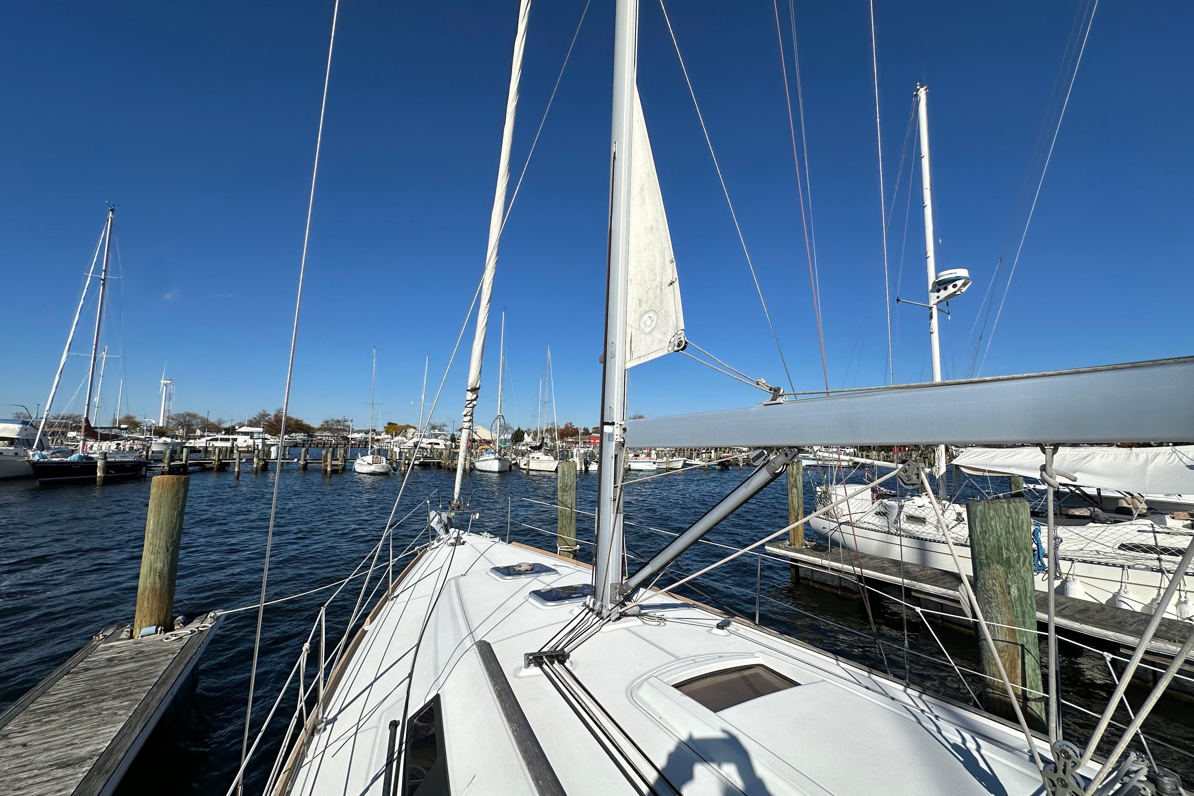 Beneteau Oceanis 37 sailboat docked at marina, clear blue sky, 2015 model.