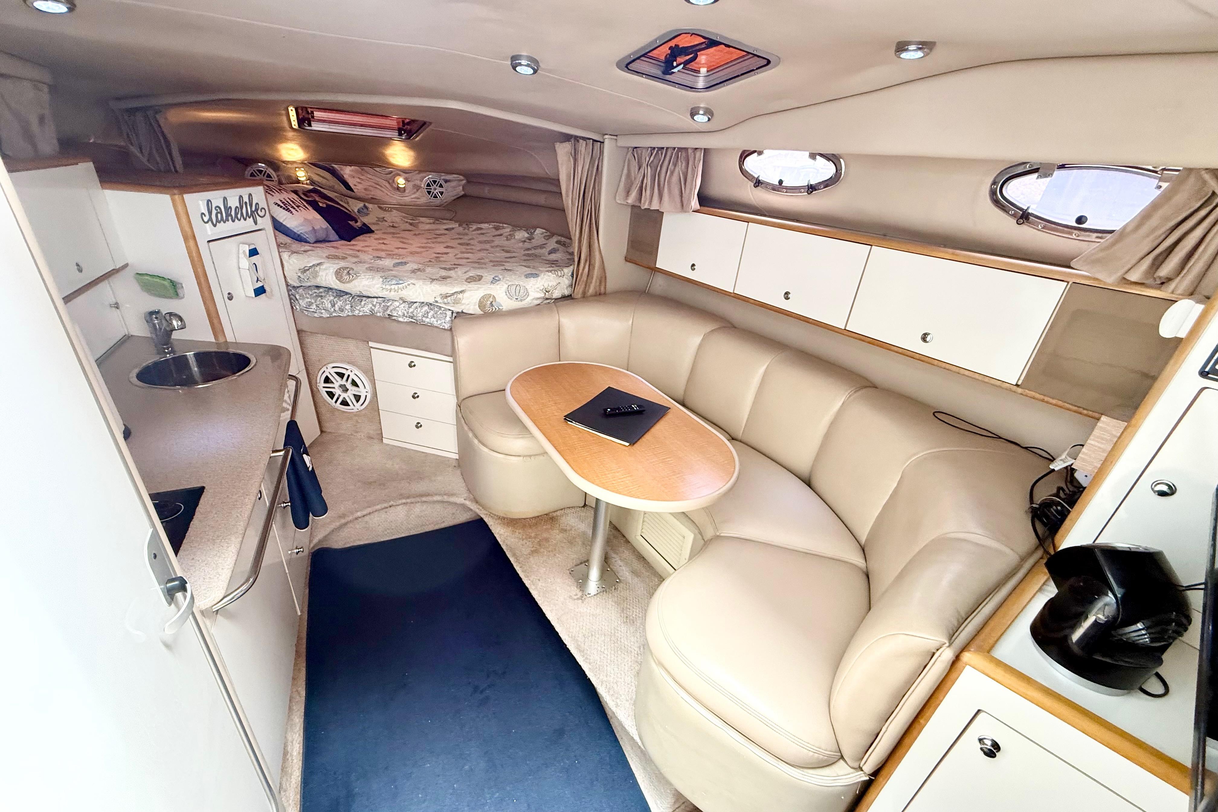 1999 Chaparral Signature 300 cabin interior with kitchenette, seating, and bed.
