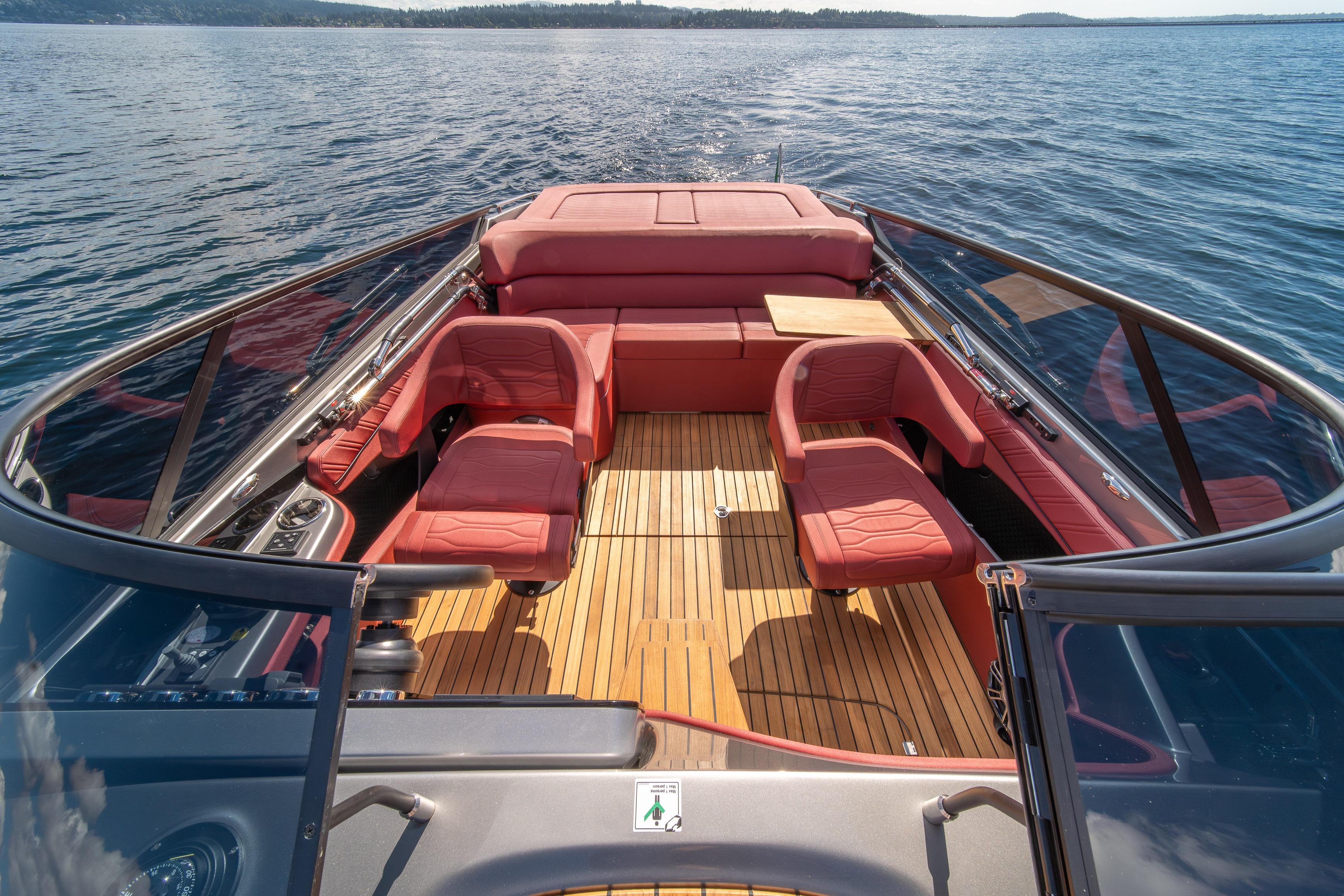 2026 Cranchi E26 Classic boat interior with red seating and wooden deck on open water.