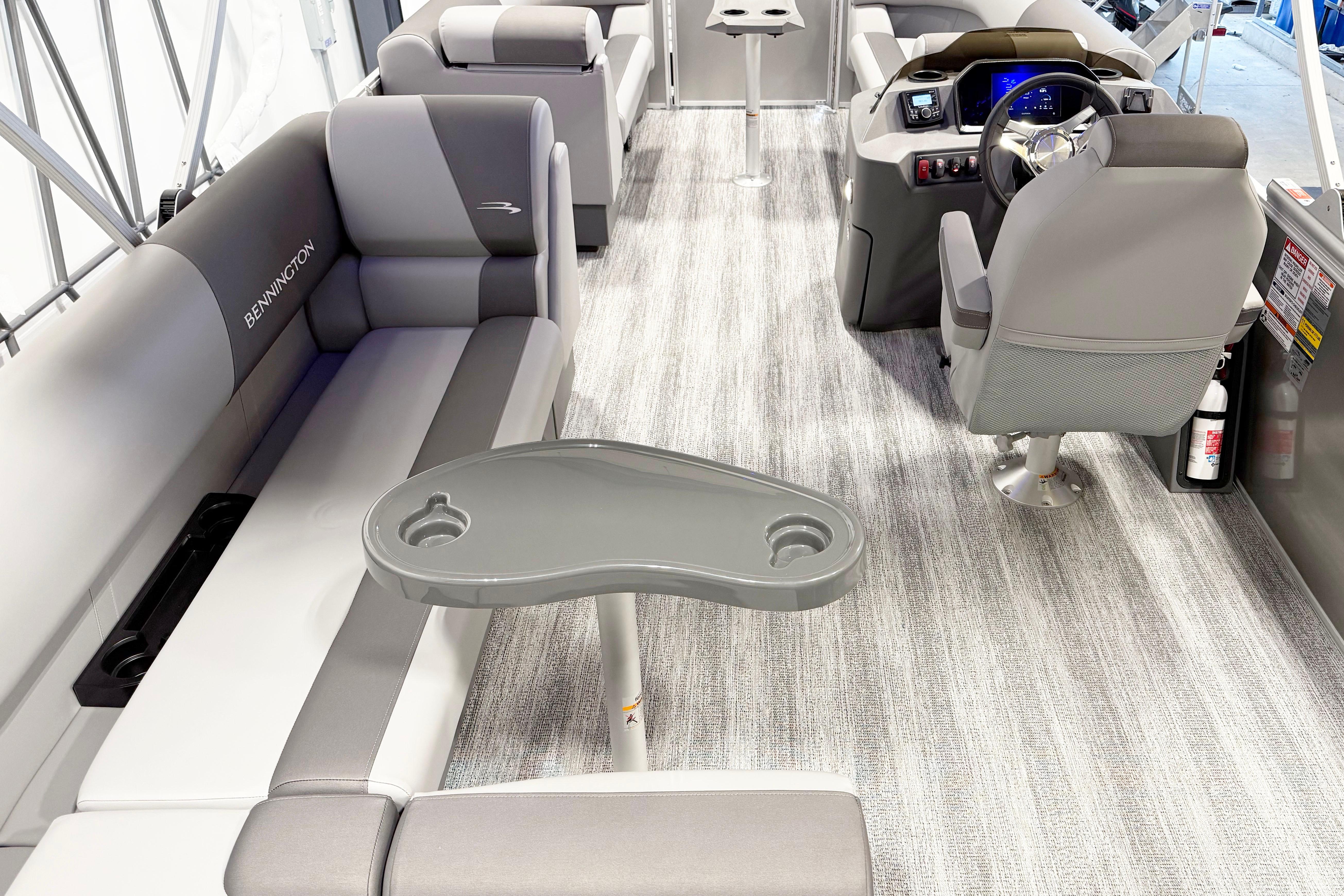 2025 Bennington 21S Cruise interior with gray seating, steering console, and table.