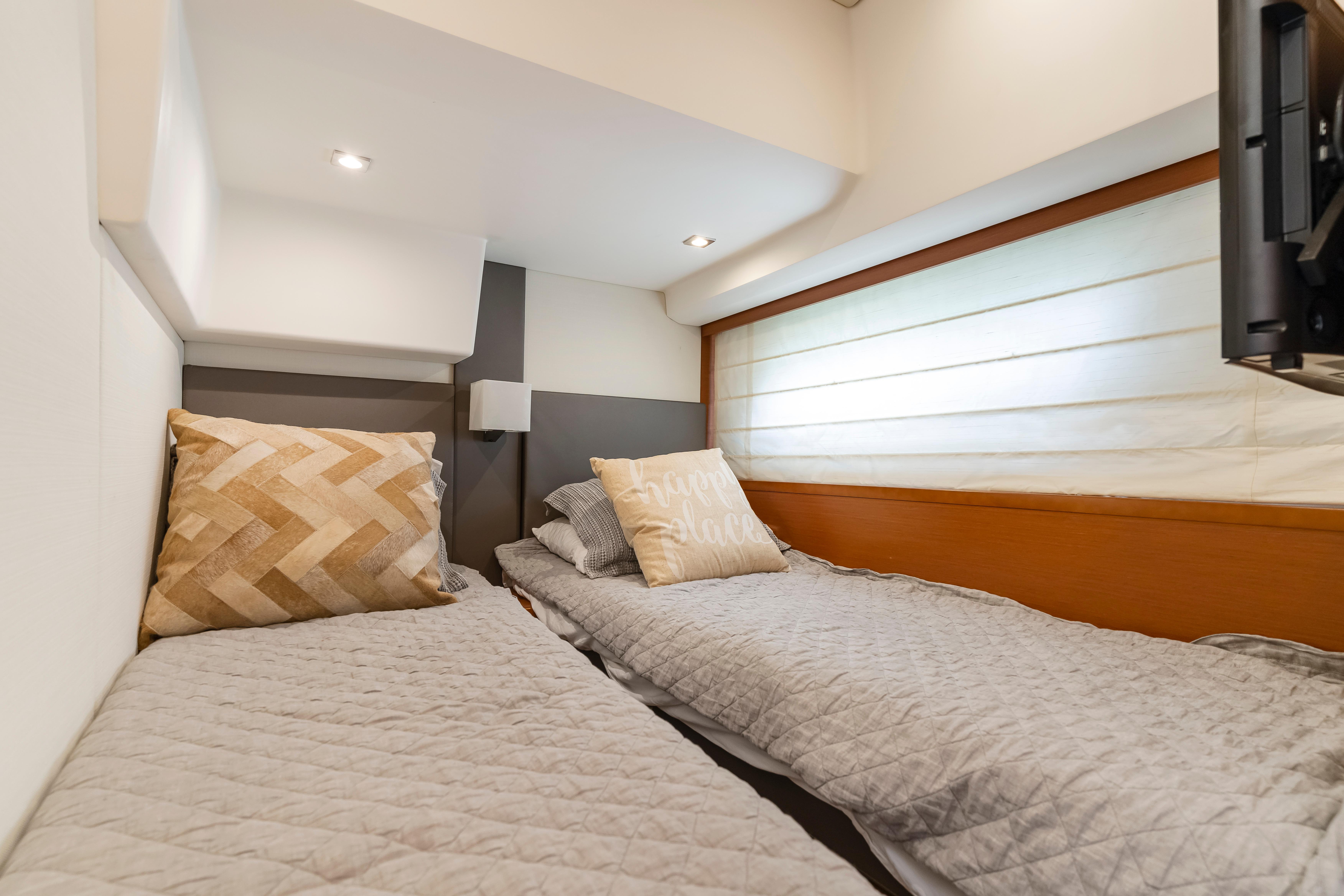 Luxurious twin cabin in 2017 Prestige 500 yacht, featuring cozy bedding and modern decor.