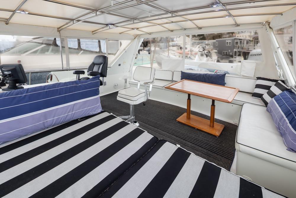 Luxurious 1991 Tollycraft 57 Pilothouse Motor Yacht interior with striped seating and wooden table.