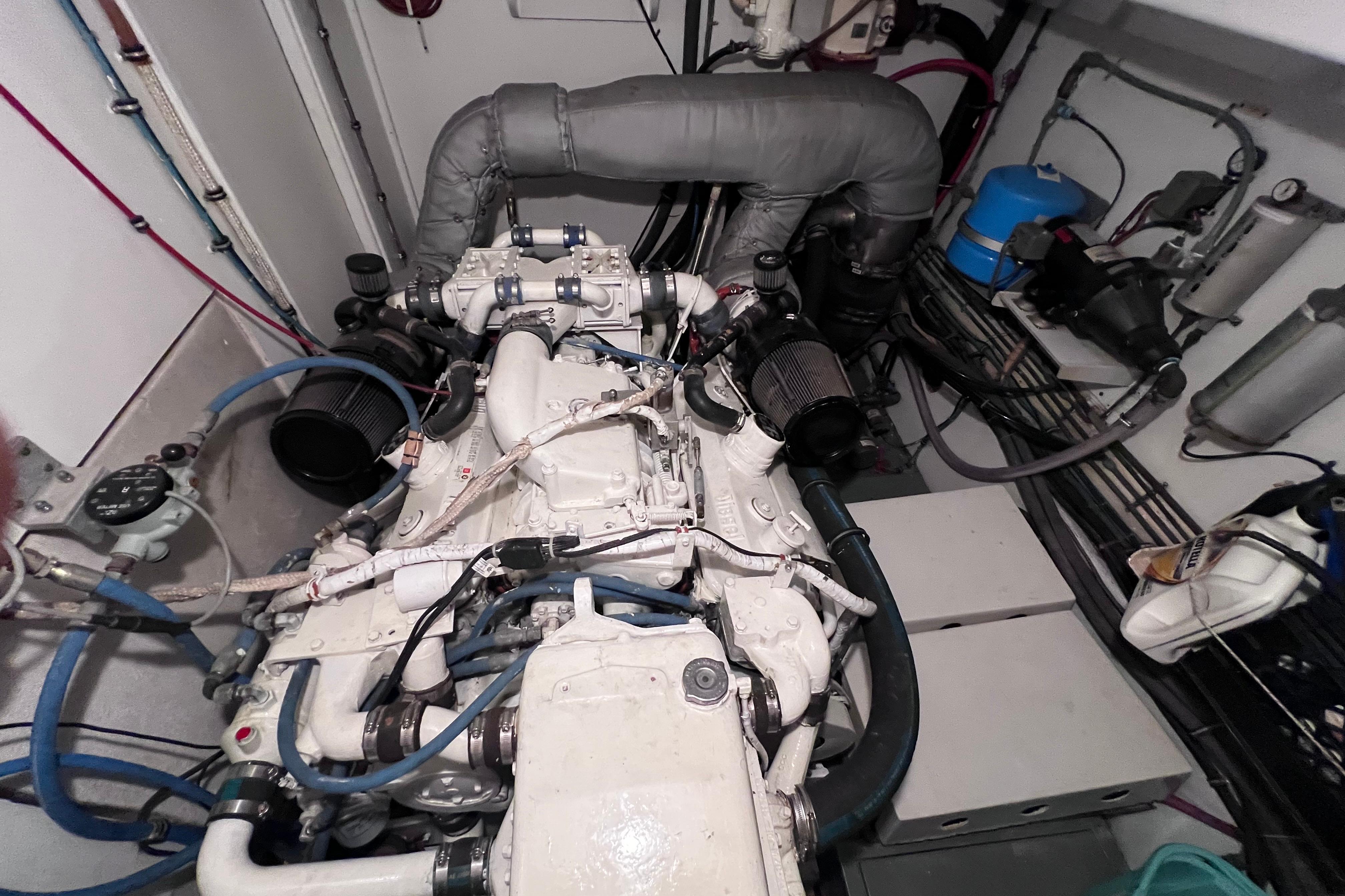 Engine room of a 1987 Hatteras 70 Cockpit Motor Yacht, showcasing detailed machinery.