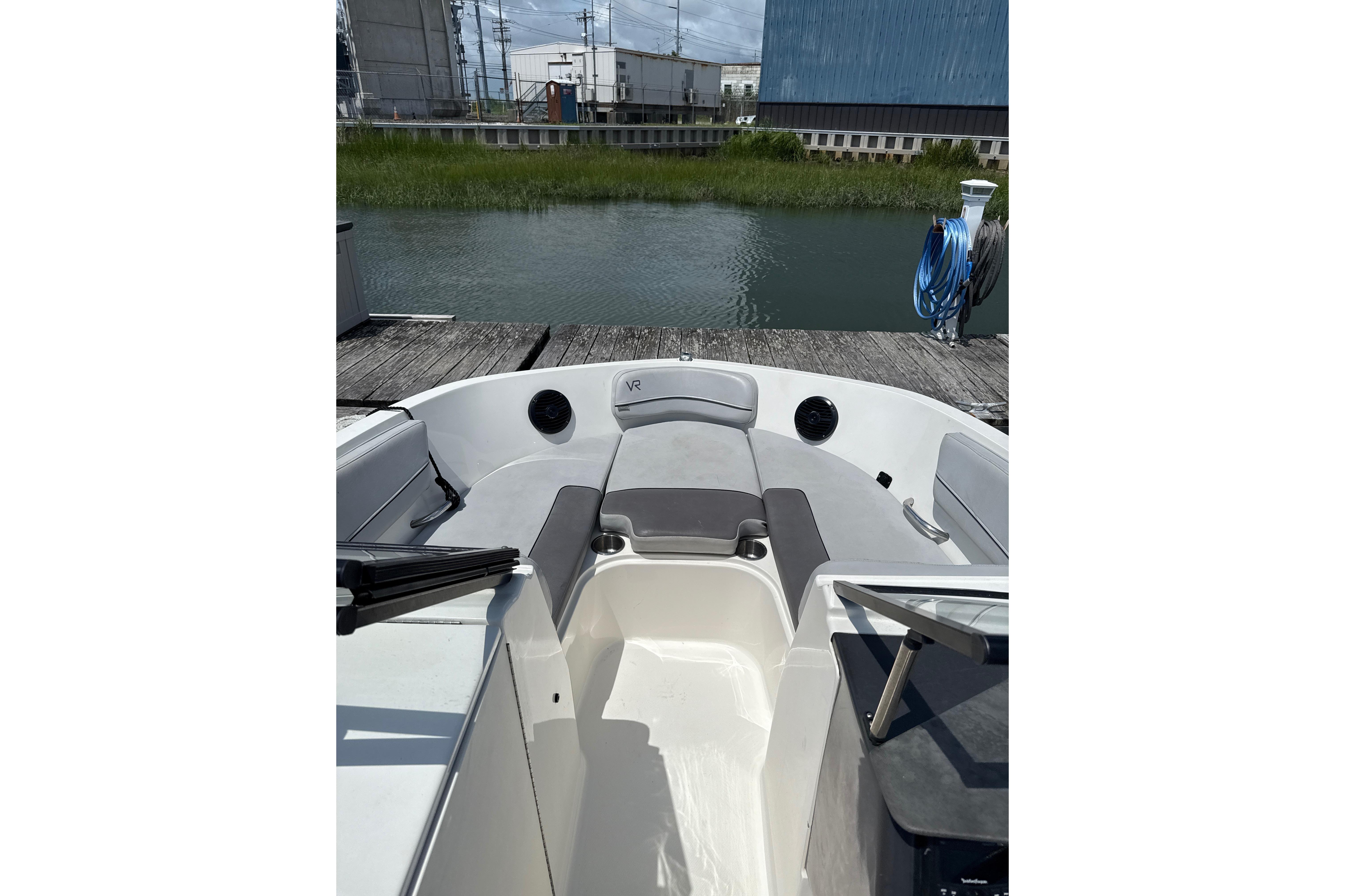 2023 Bayliner VR6 Bowrider OB interior at dock, showcasing seating and water view.