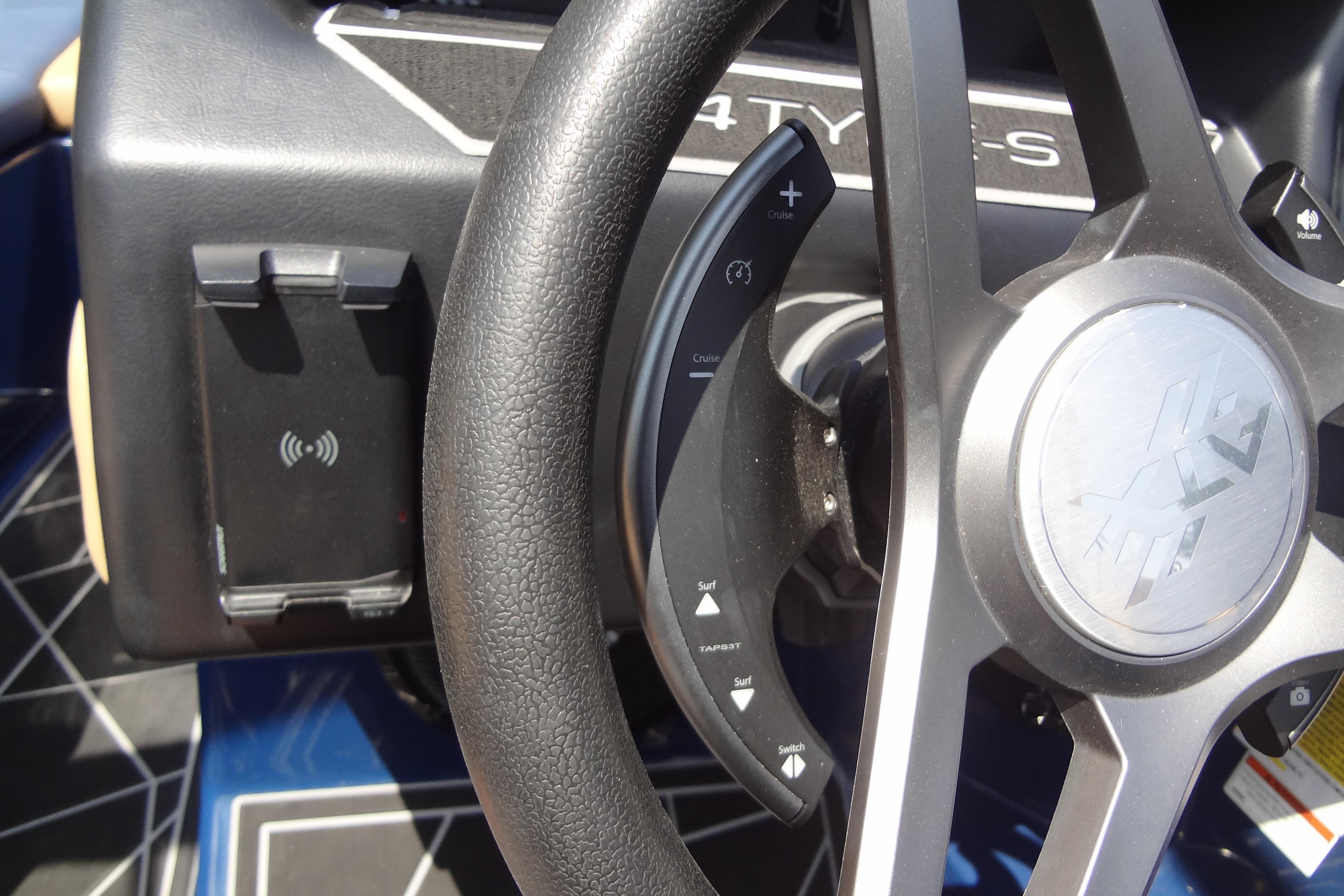 Steering wheel of 2022 ATX Surf Boats 24 Type-S with control buttons and phone holder.