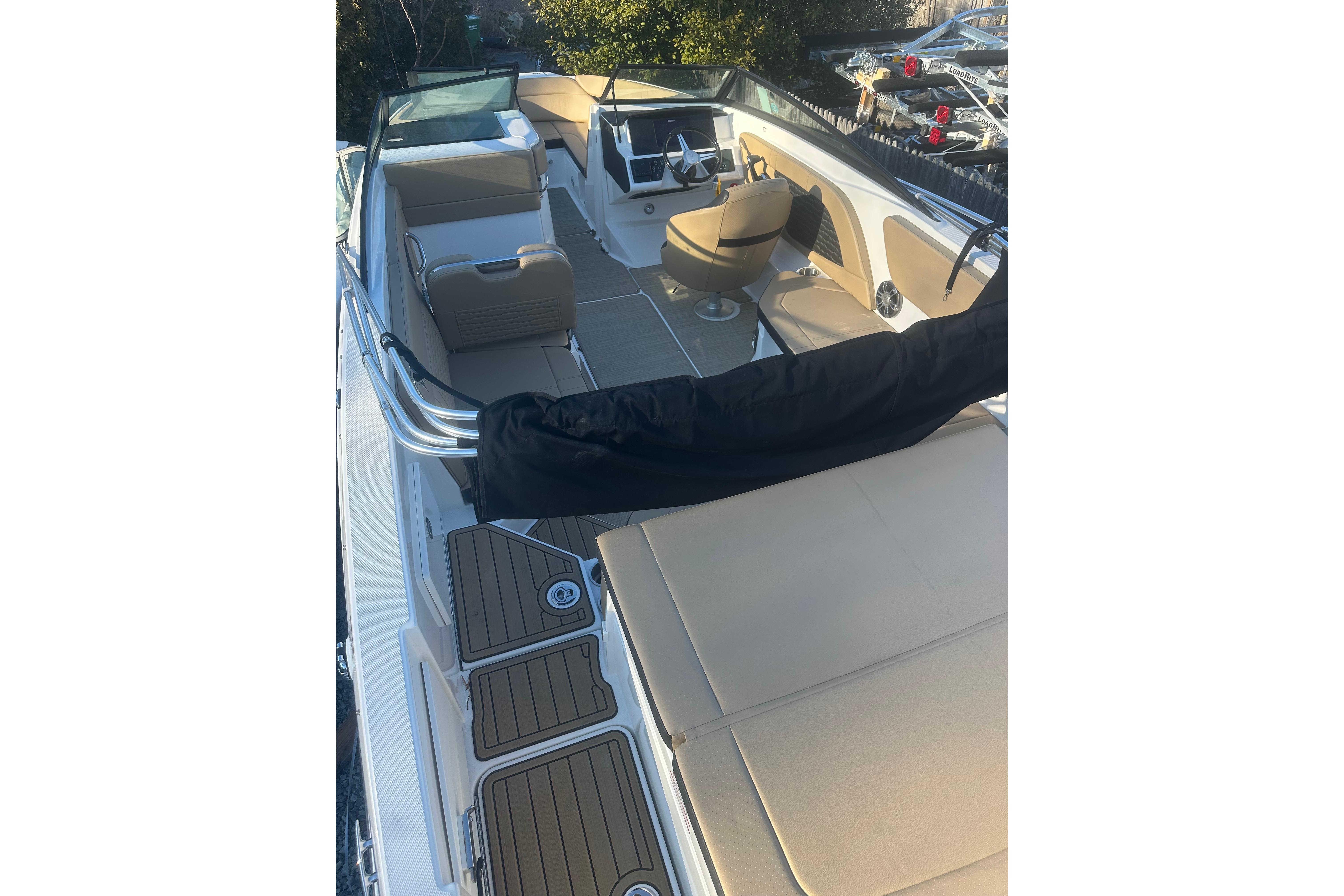 2023 Sea Ray SPX 230 Outboard boat interior with beige seating and modern dashboard.