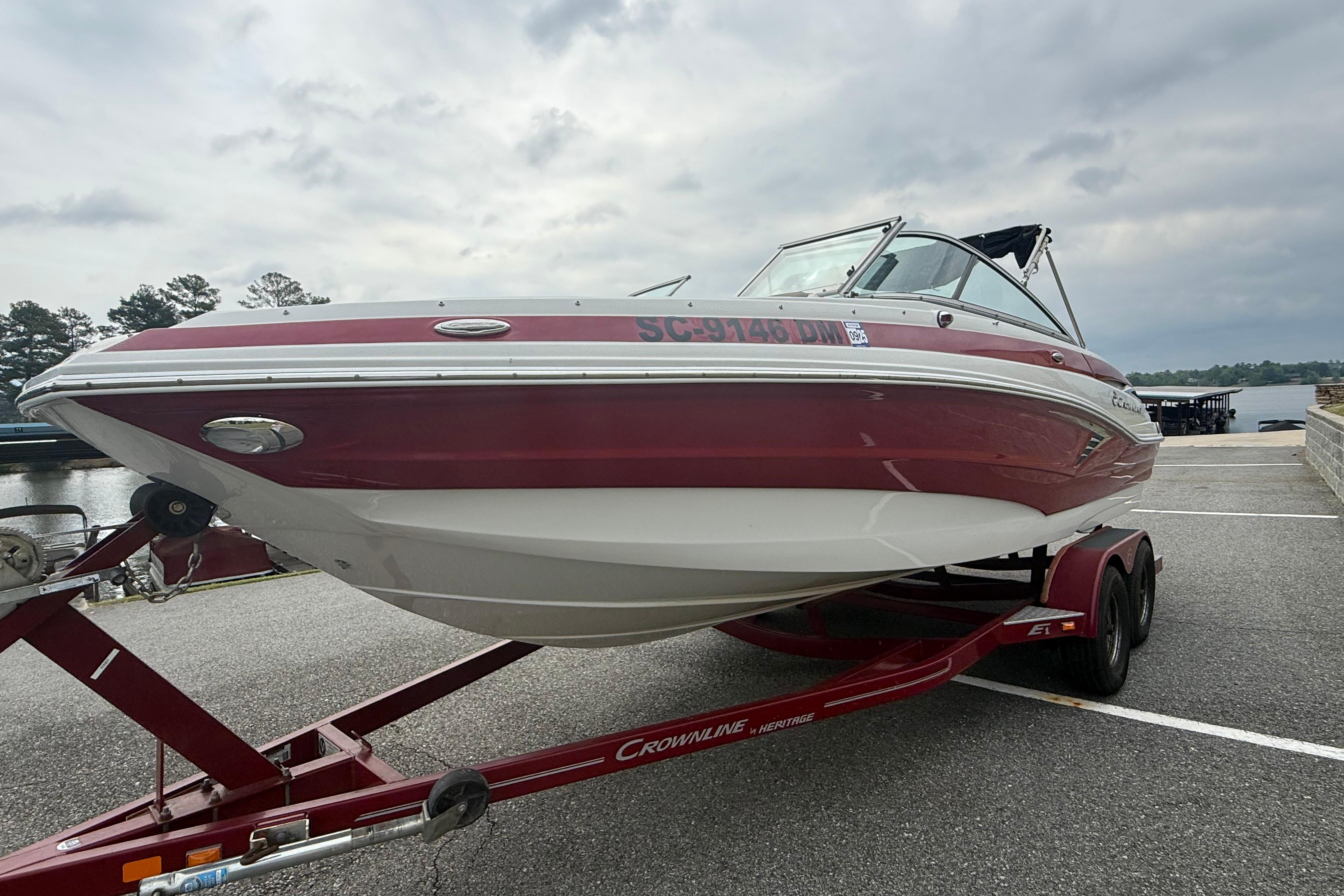 2017 Crownline Eclipse E1 XS boat on trailer, parked near a lake under cloudy skies.