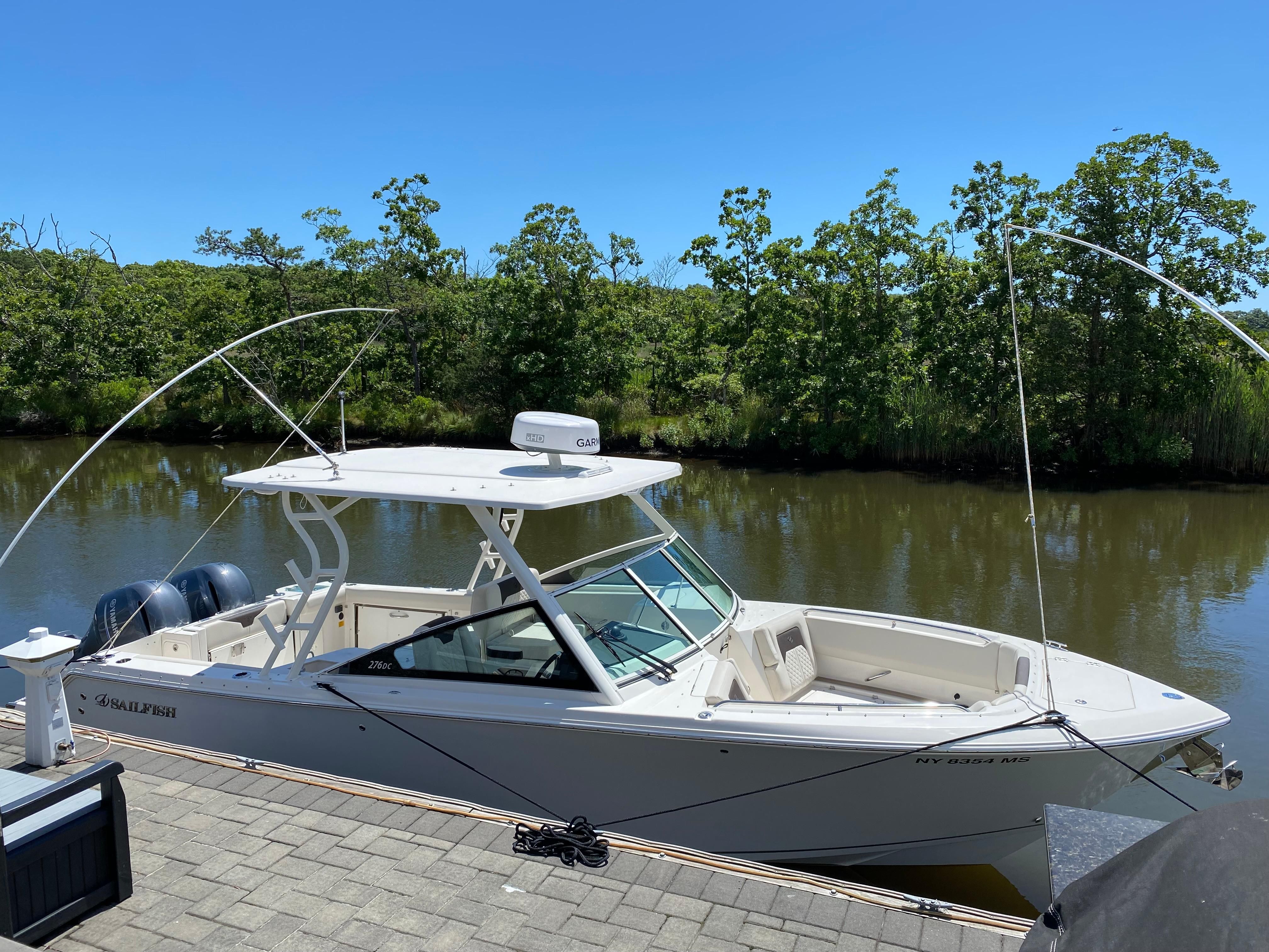 2022 Sailfish 276 DC boat docked by the riverside.