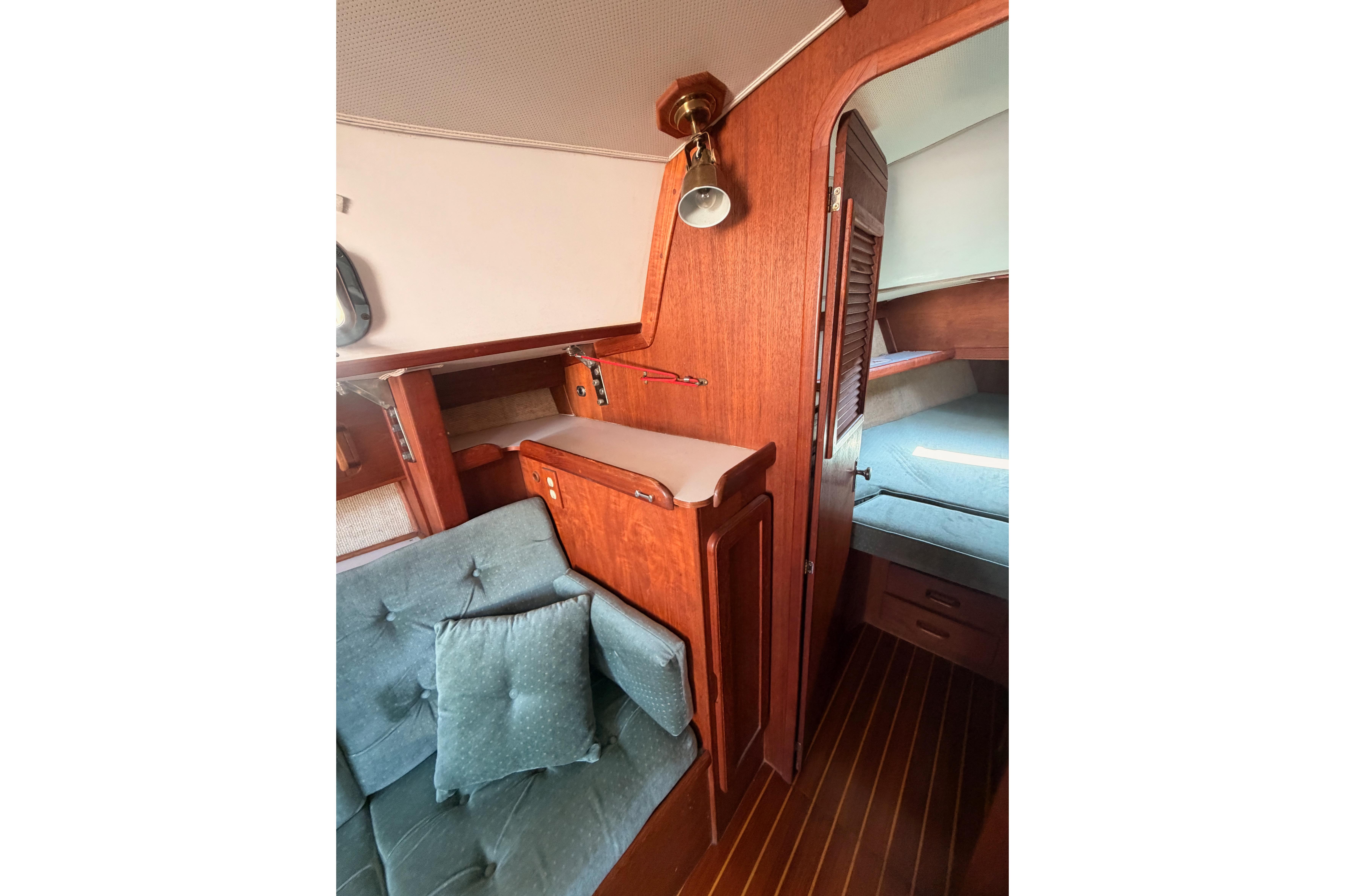 Interior of 1991 Caliber 33 sailboat with wooden cabinetry and cushioned seating.
