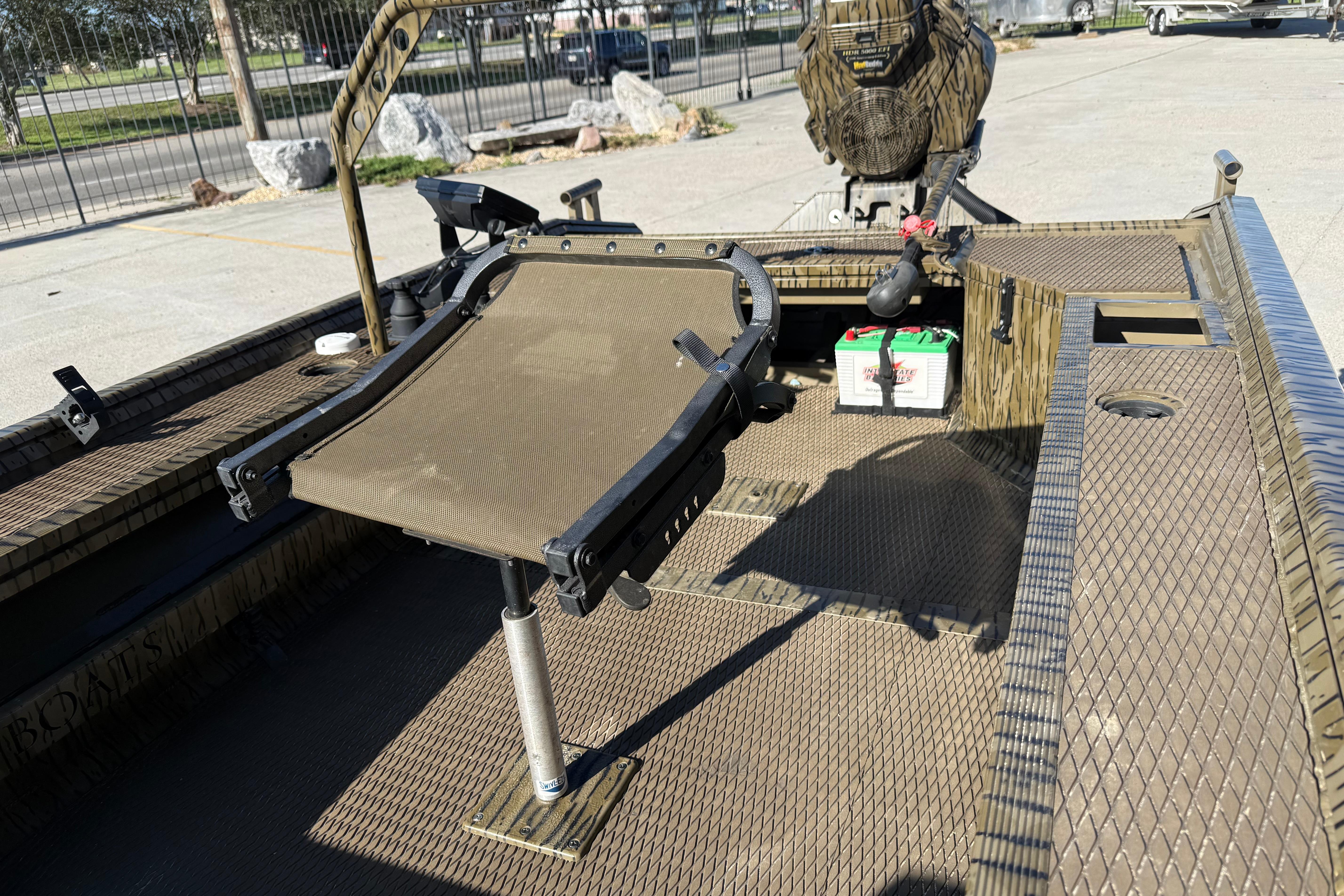 2022 Prodigy 1854 boat interior with seat and battery, parked outdoors.