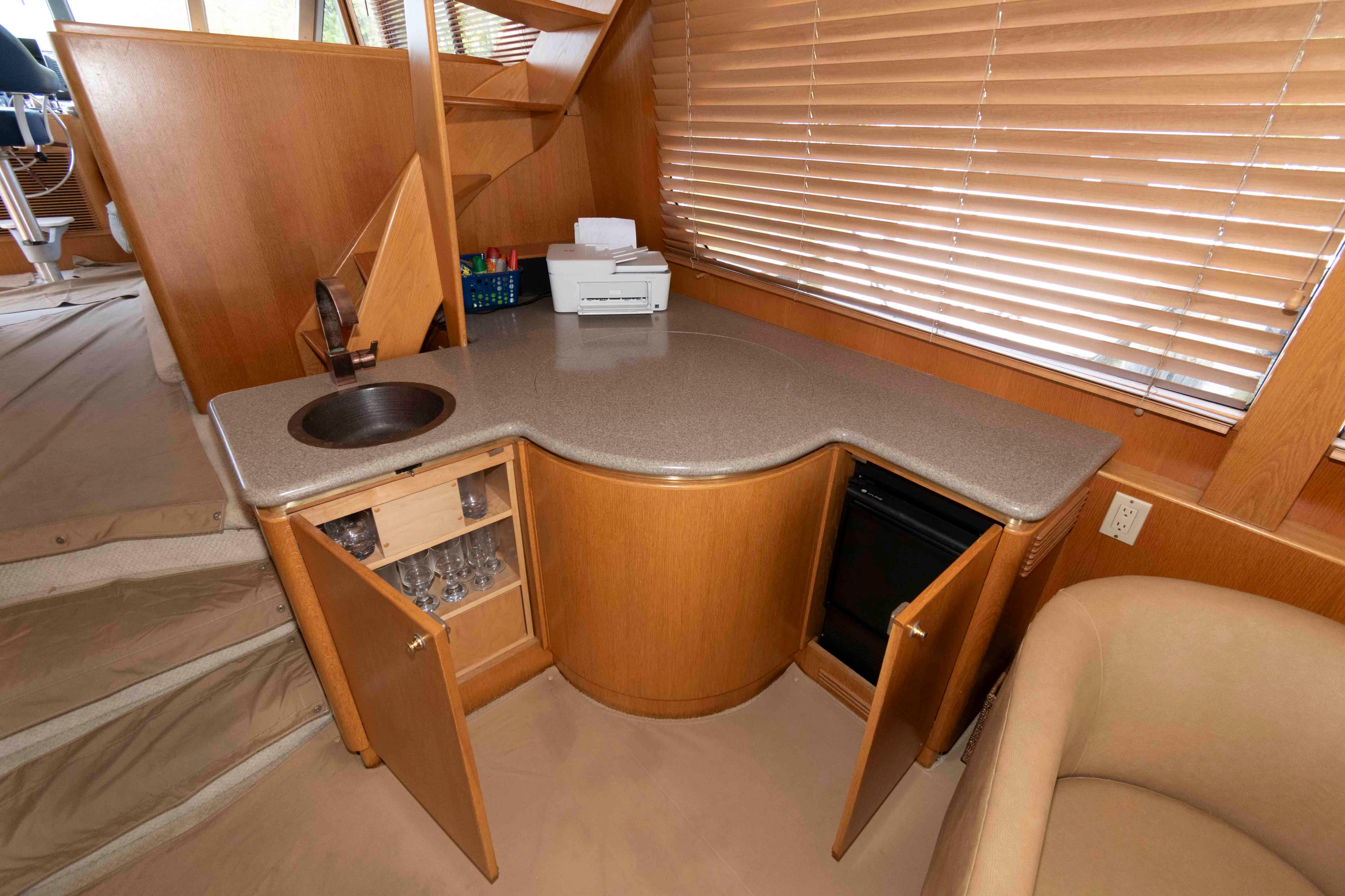 Luxurious 1999 West Bay 58 Sonship Pilothouse MY interior with kitchenette and wooden cabinetry.
