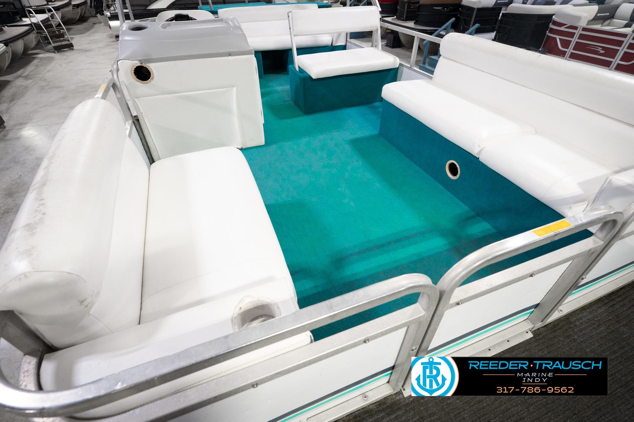 1992 Godfrey Sweetwater pontoon boat interior with white seating and teal flooring.