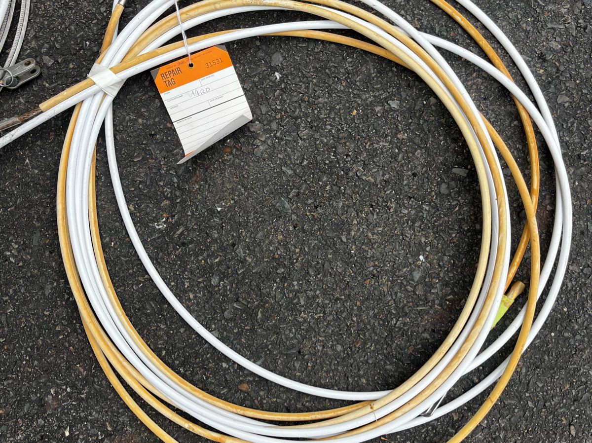 A bundle of cables or ropes lies on the ground.