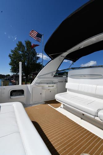 1997 Sea Ray 400 Sundancer yacht with white seating and American flag in background.