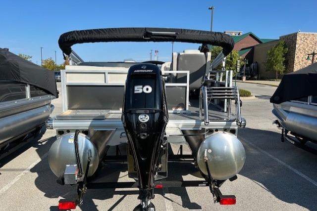 2026 Sun Tracker Bass Buggy 16 XL Select pontoon boat with Mercury 50 engine, parked outdoors.