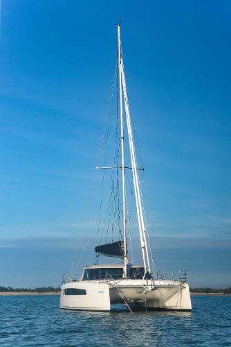 2025 Seawind 1170 catamaran sailing on calm waters under a clear blue sky.