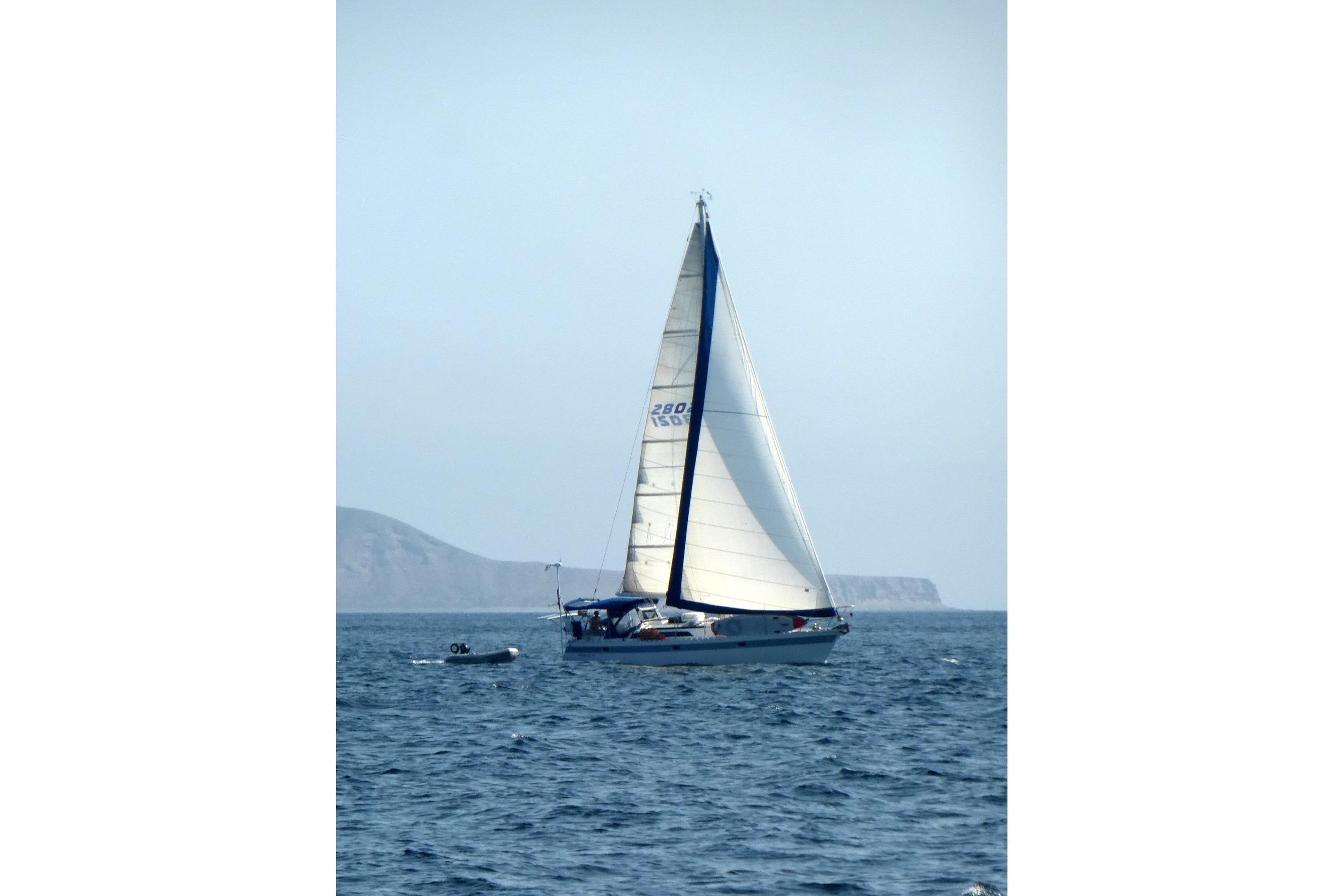 Sailing yacht Norseman 400 from 1987 on open sea with distant coastline.