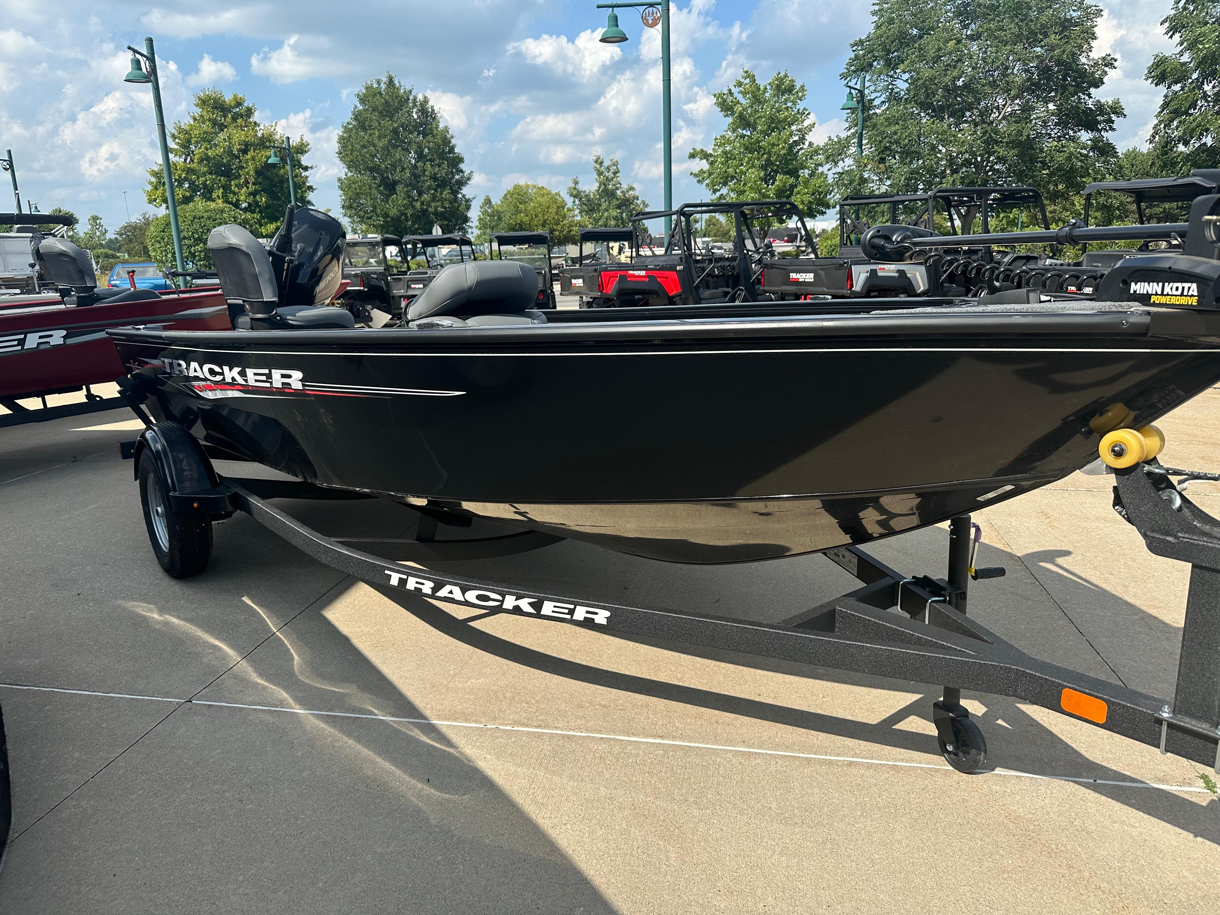 2025 Tracker Super Guide V-16 T boat on trailer, outdoors, under a blue sky.