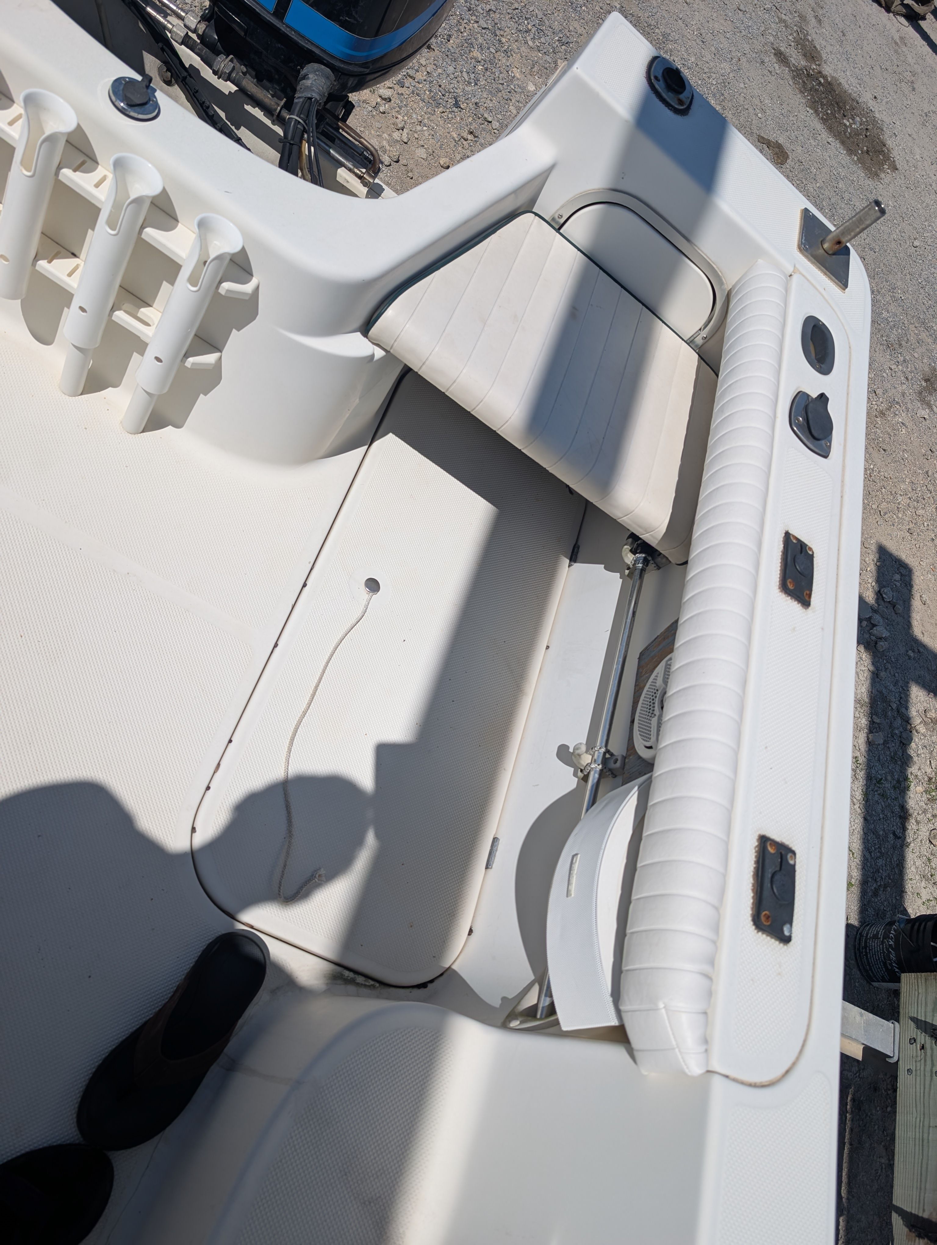 The image shows the cockpit of a 2001 Trophy Bayliner boat with white seating and rod holders.