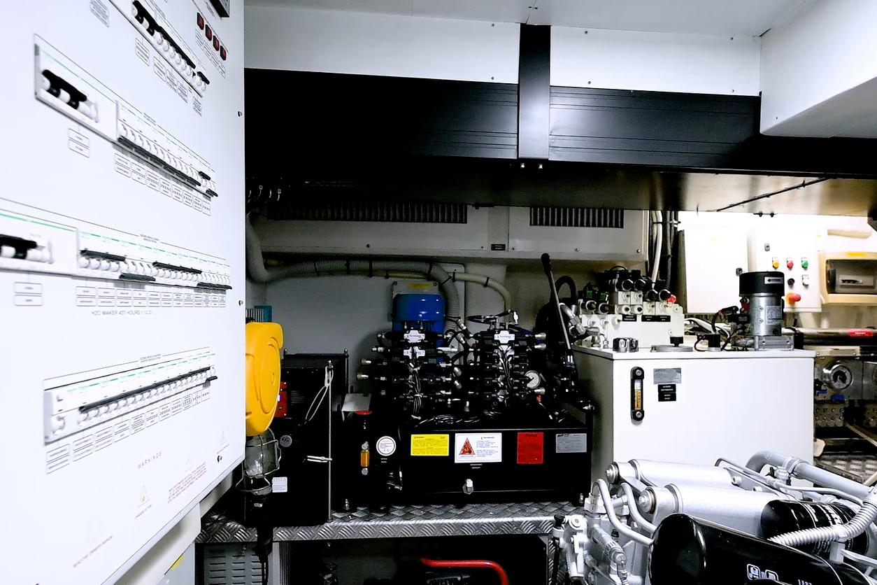 Engine room of a 2015 Pershing 92 yacht, showcasing control panels and machinery.