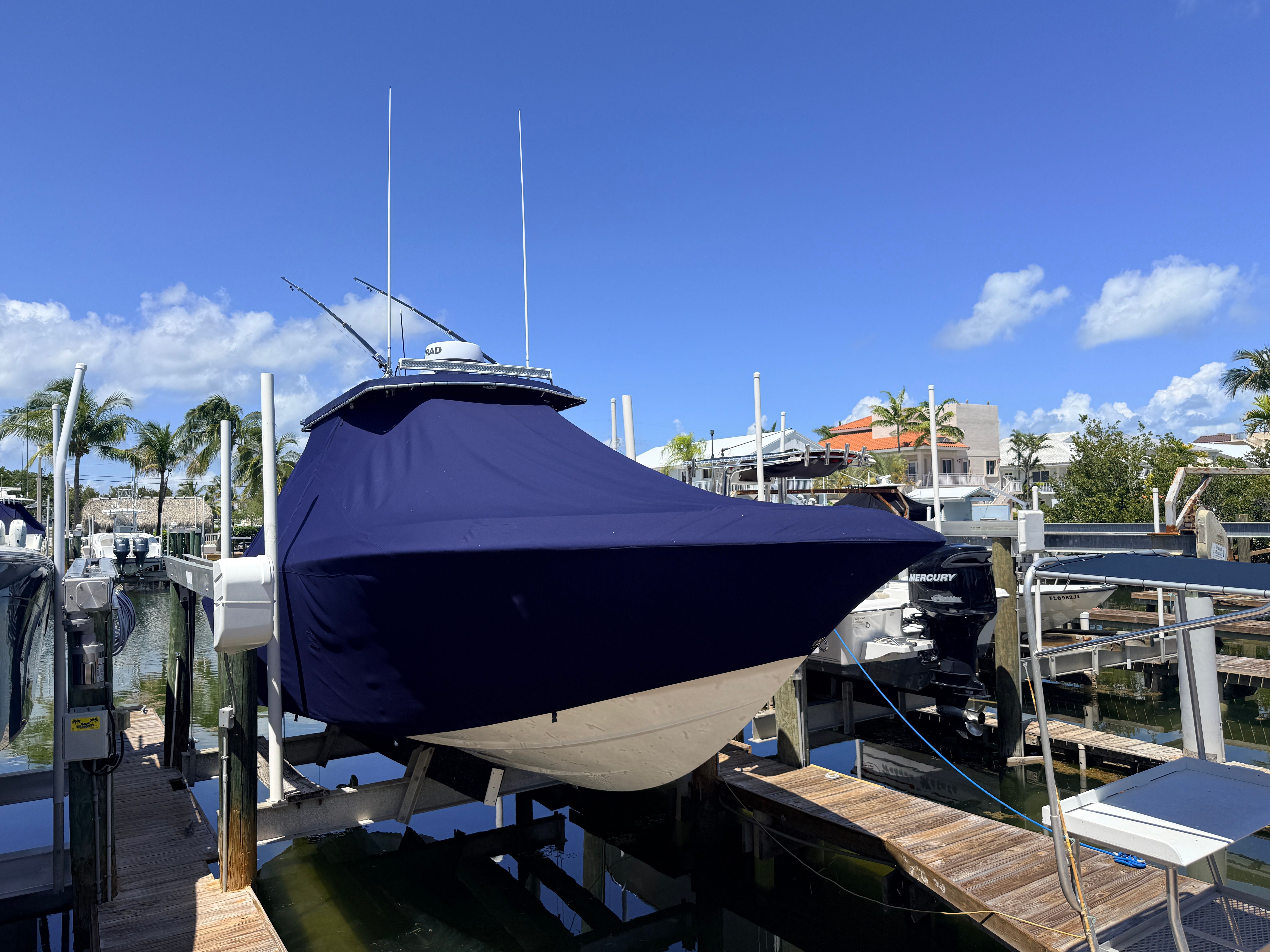 2007 Fountain 32 Center Console boat with cover in marina.