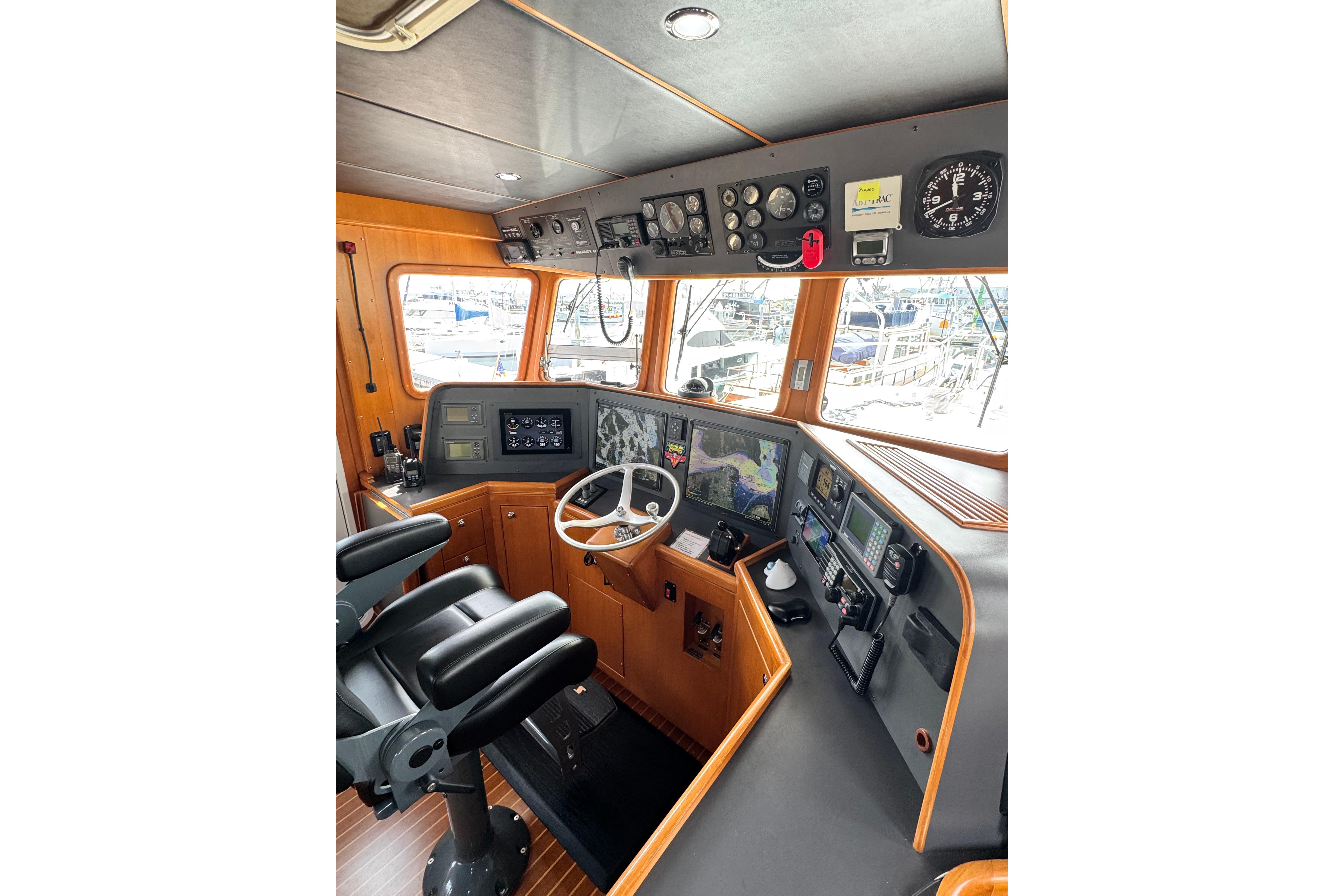 Pilothouse of 2005 Nordhavn 47 yacht with navigation equipment and steering wheel.