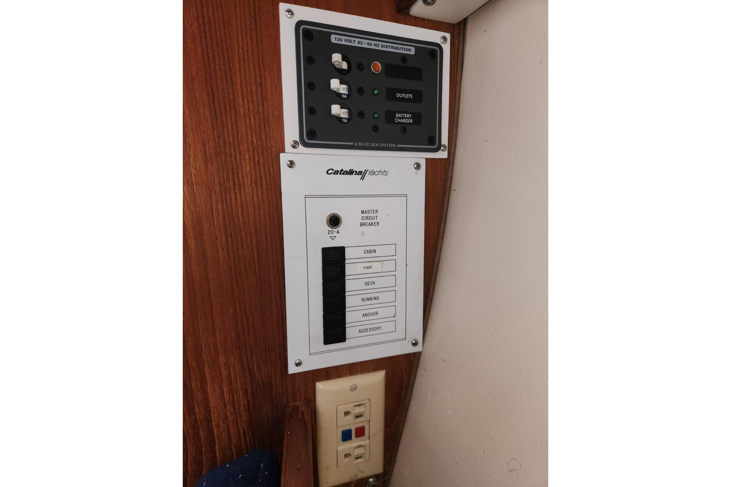 Electrical panel on a 1990 Catalina Capri yacht, featuring circuit breakers and outlets.