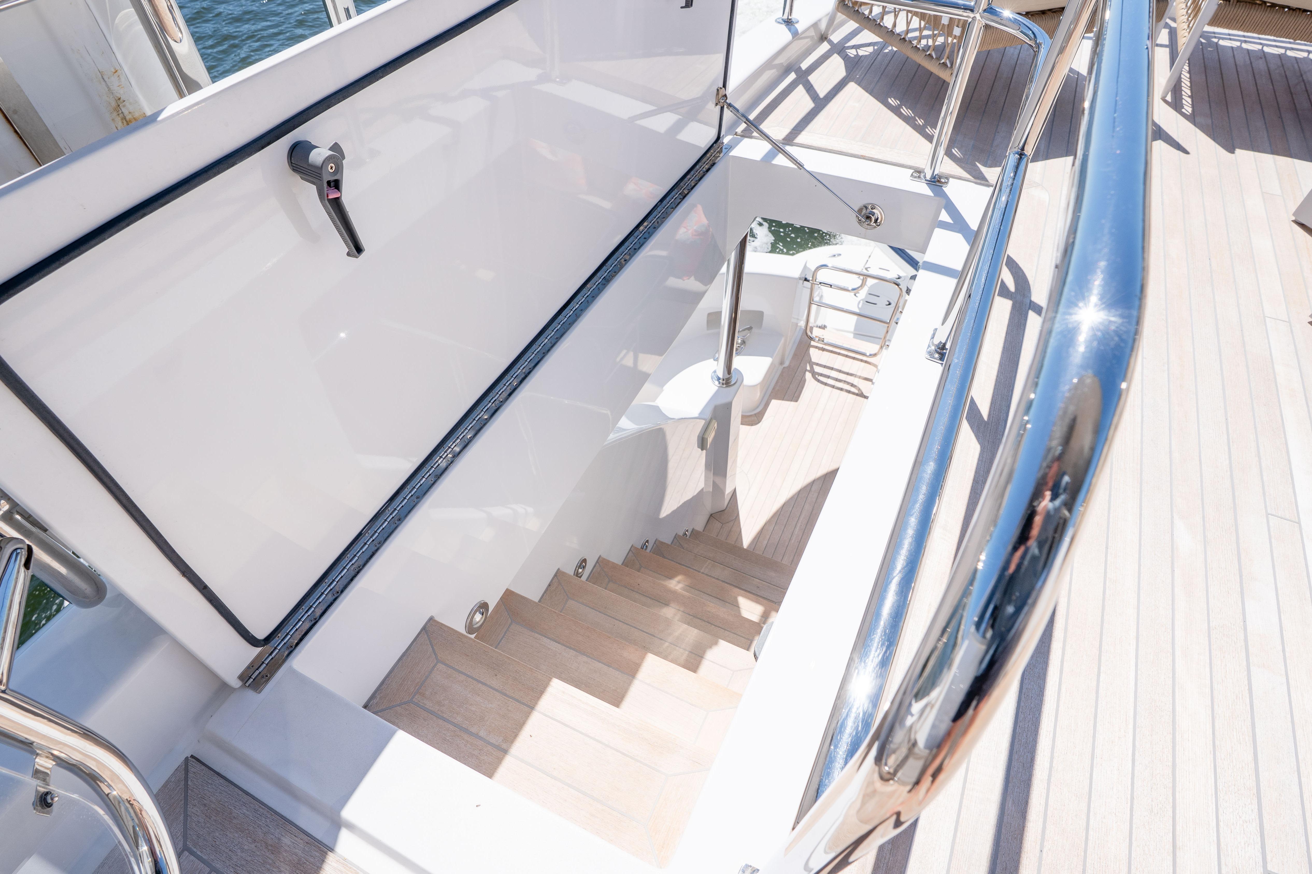 Staircase on 2021 Hatteras M75 Panacera yacht with sleek railing and wooden steps.