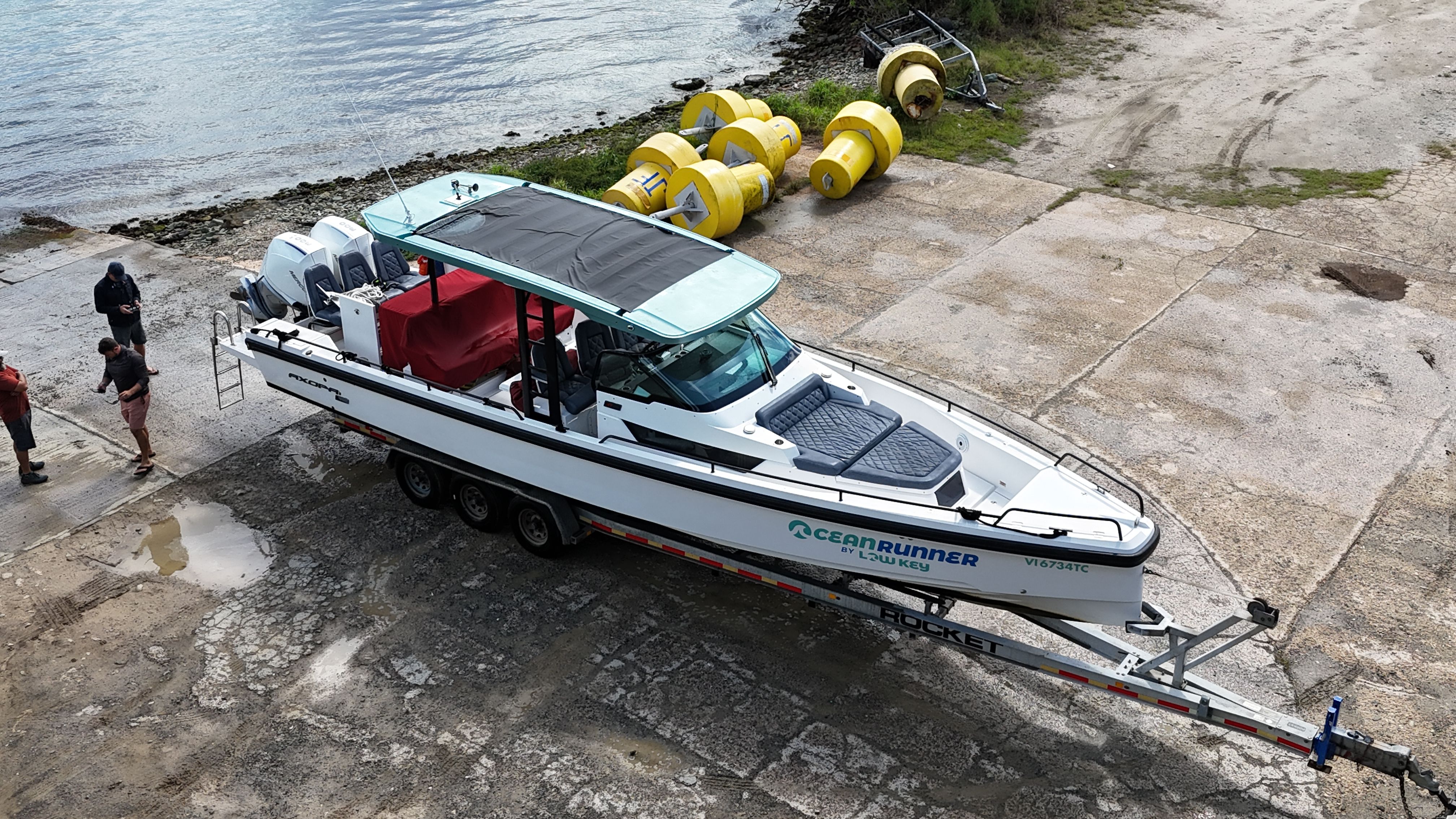 A 2020 Axopar 37 SUN TOP boat on a trailer near a body of water.