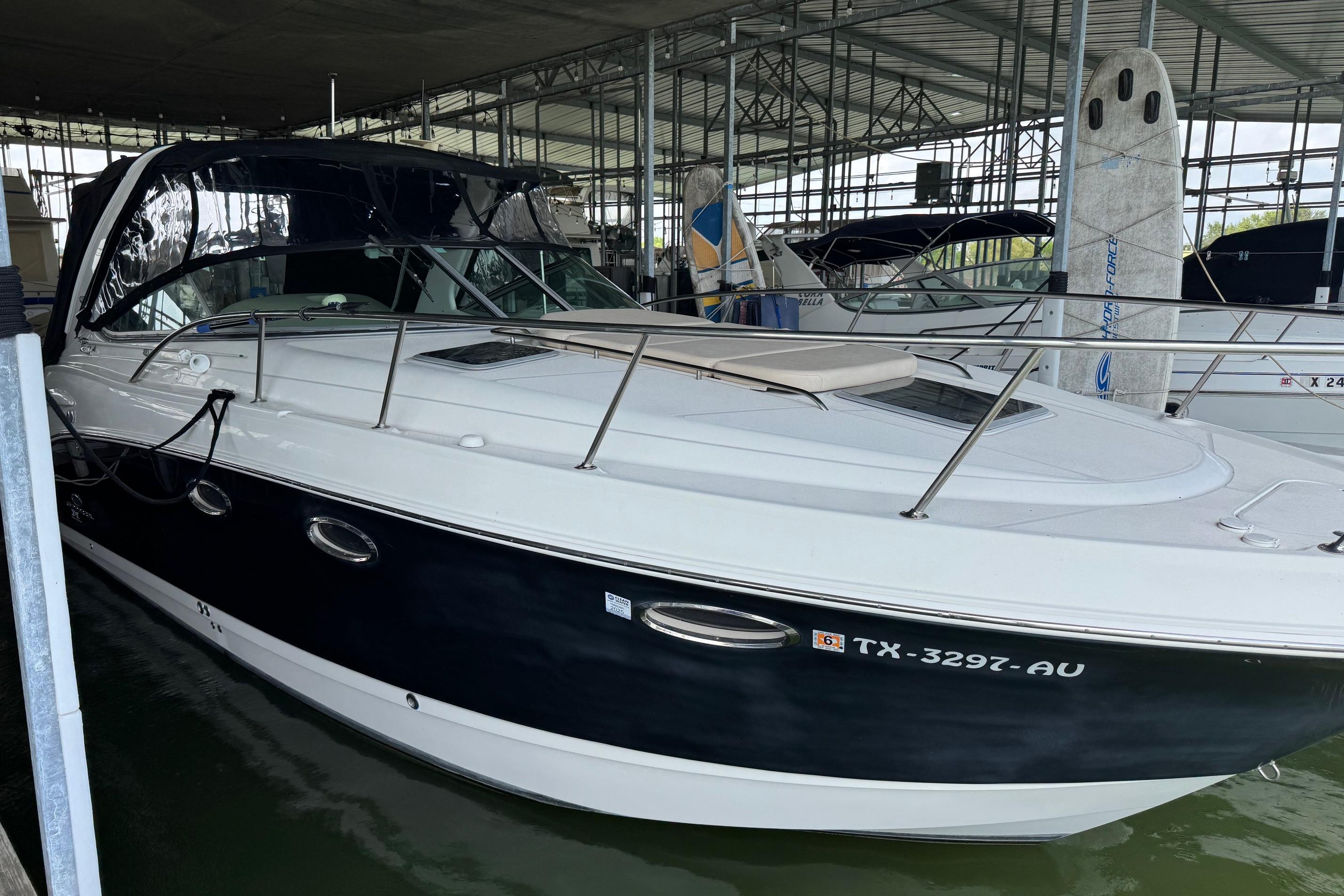 2006 Chaparral 330 Signature boat docked in a marina, featuring sleek design and black hull.
