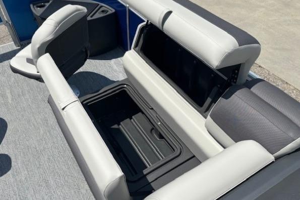 2026 Sun Tracker Fishin' Barge 20 DLX seating with storage compartment open.