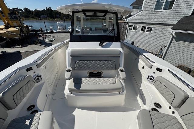 2026 Pursuit S 328 Sport boat interior with cushioned seating and waterfront view.