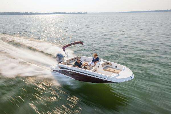 2025 Hurricane SunDeck Sport 205 OB speeding on open water, showcasing sleek design and performance.